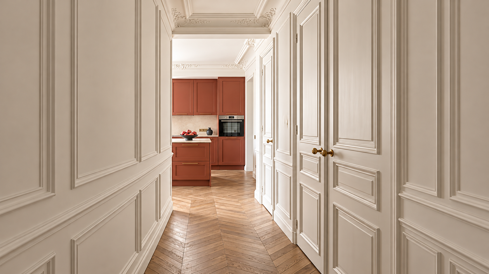 Porte blanche avec moulures menant à une cuisine moderne avec armoires en terracotta et sol en parquet en chevron.