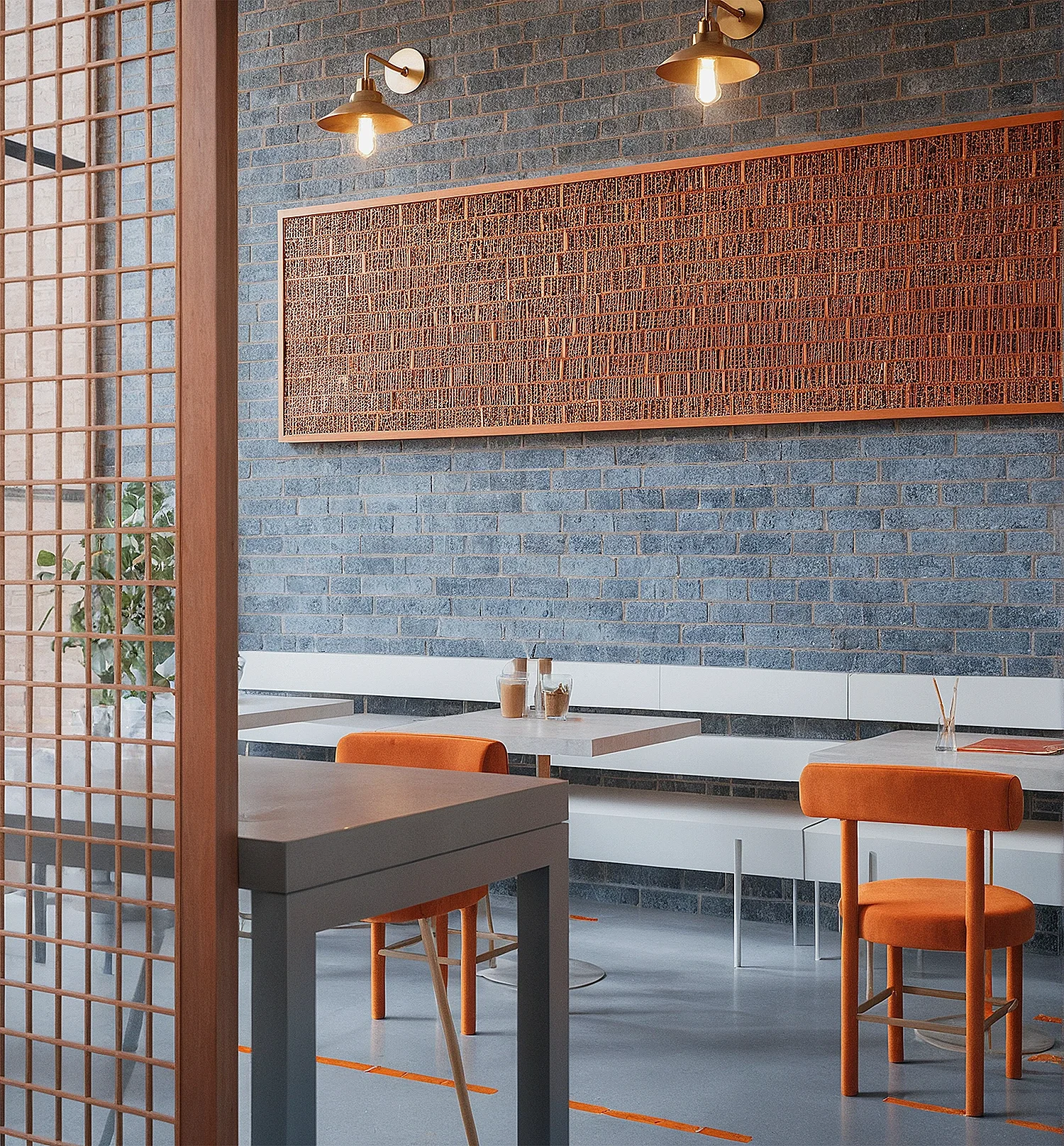 Intérieur moderne d'un restaurant-street food- avec murs en briques bleues et décoration en bois, comprenant des tables, des chaises orange, un mural en bois, et un éclairage suspendu.