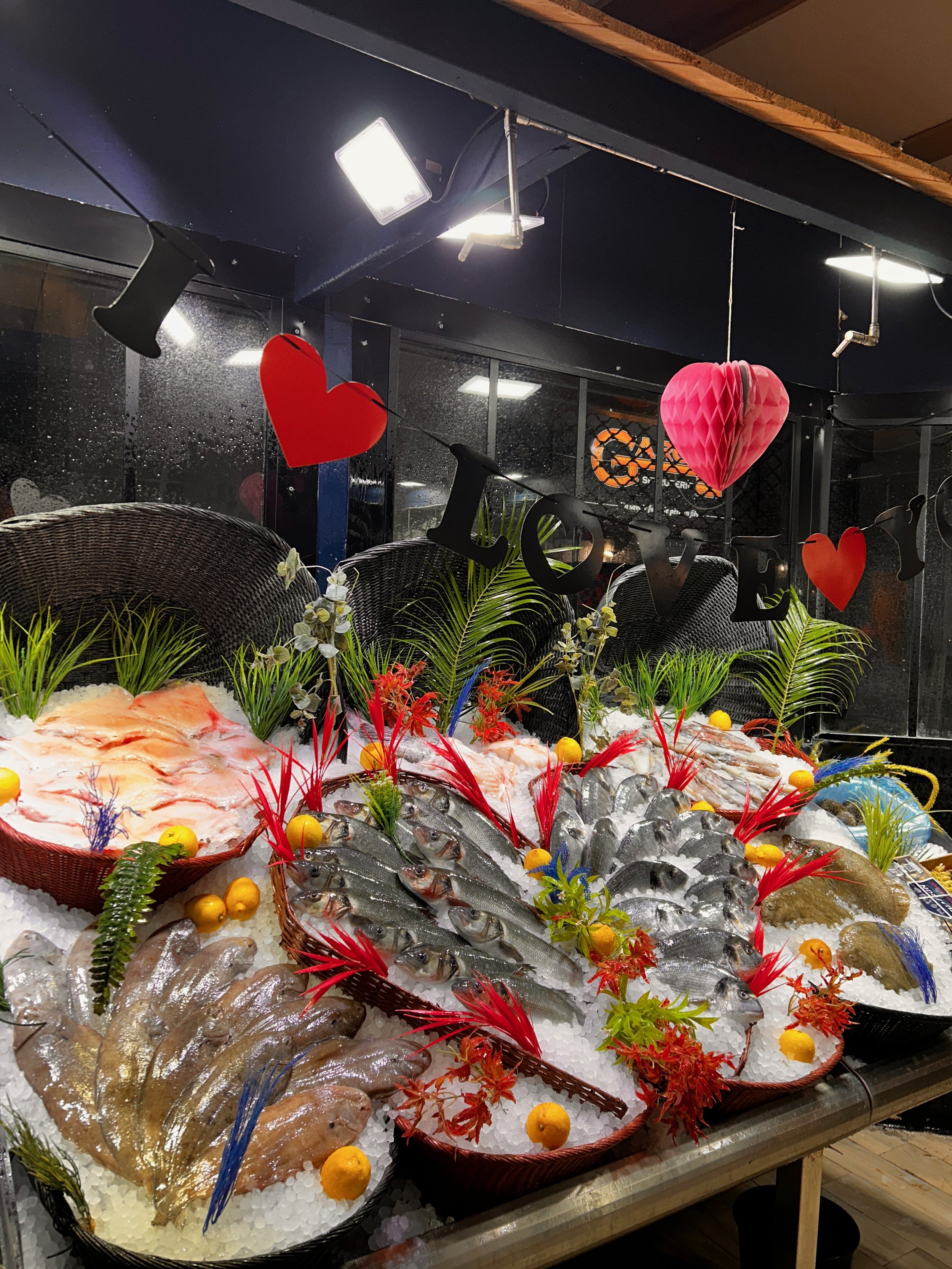 Une étal de poisson frais sur glace avec des poissons et des fruits de mer décorés avec des fleurs et des citrons, dans un restaurant ou une poissonnerie