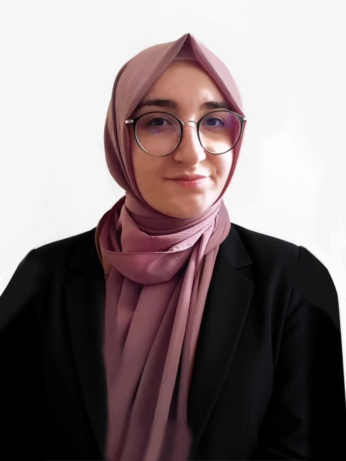 A woman with glasses wearing a pink hijab and black blazer, smiling softly against a plain white background.