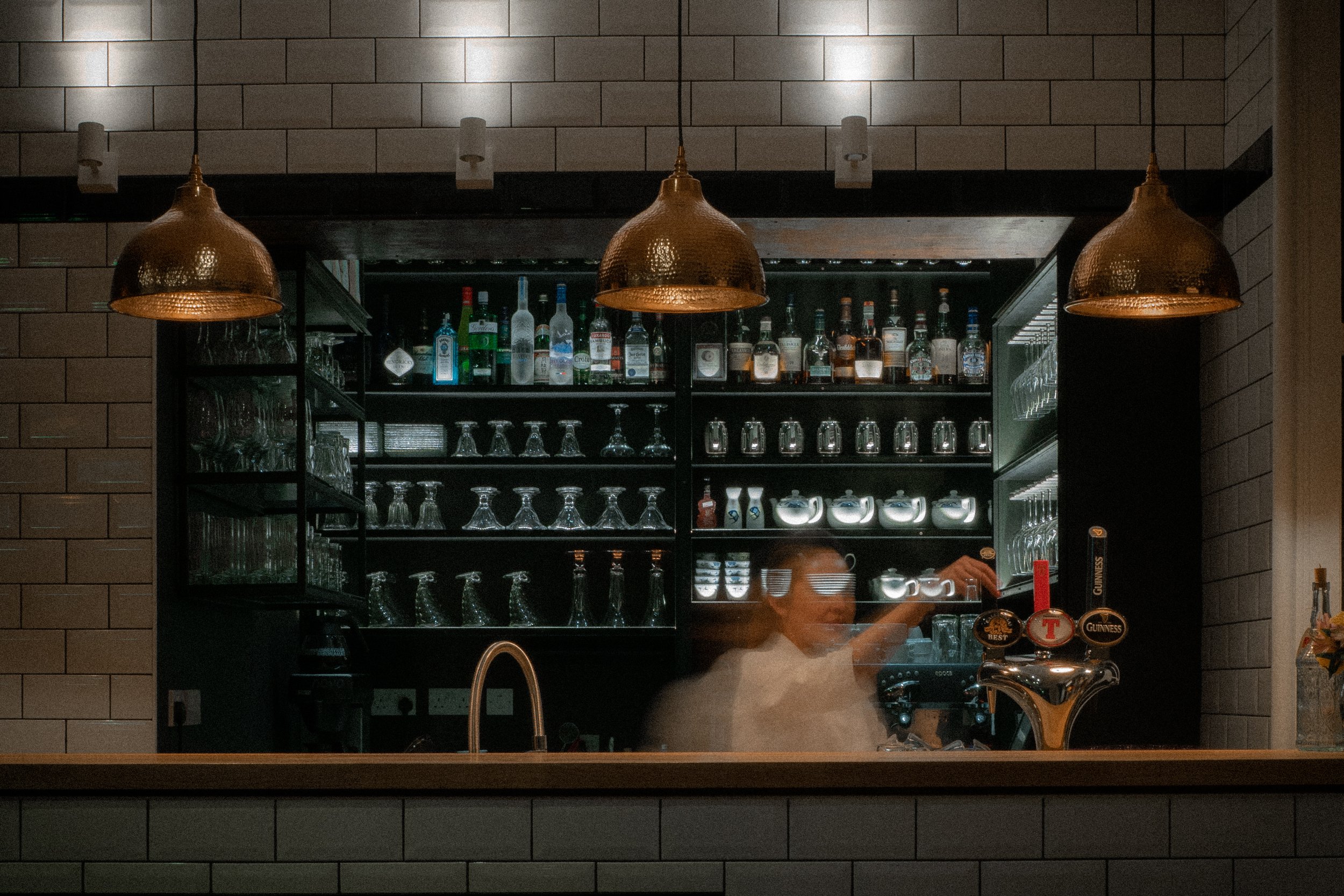 Bar view with a bartender making a drink