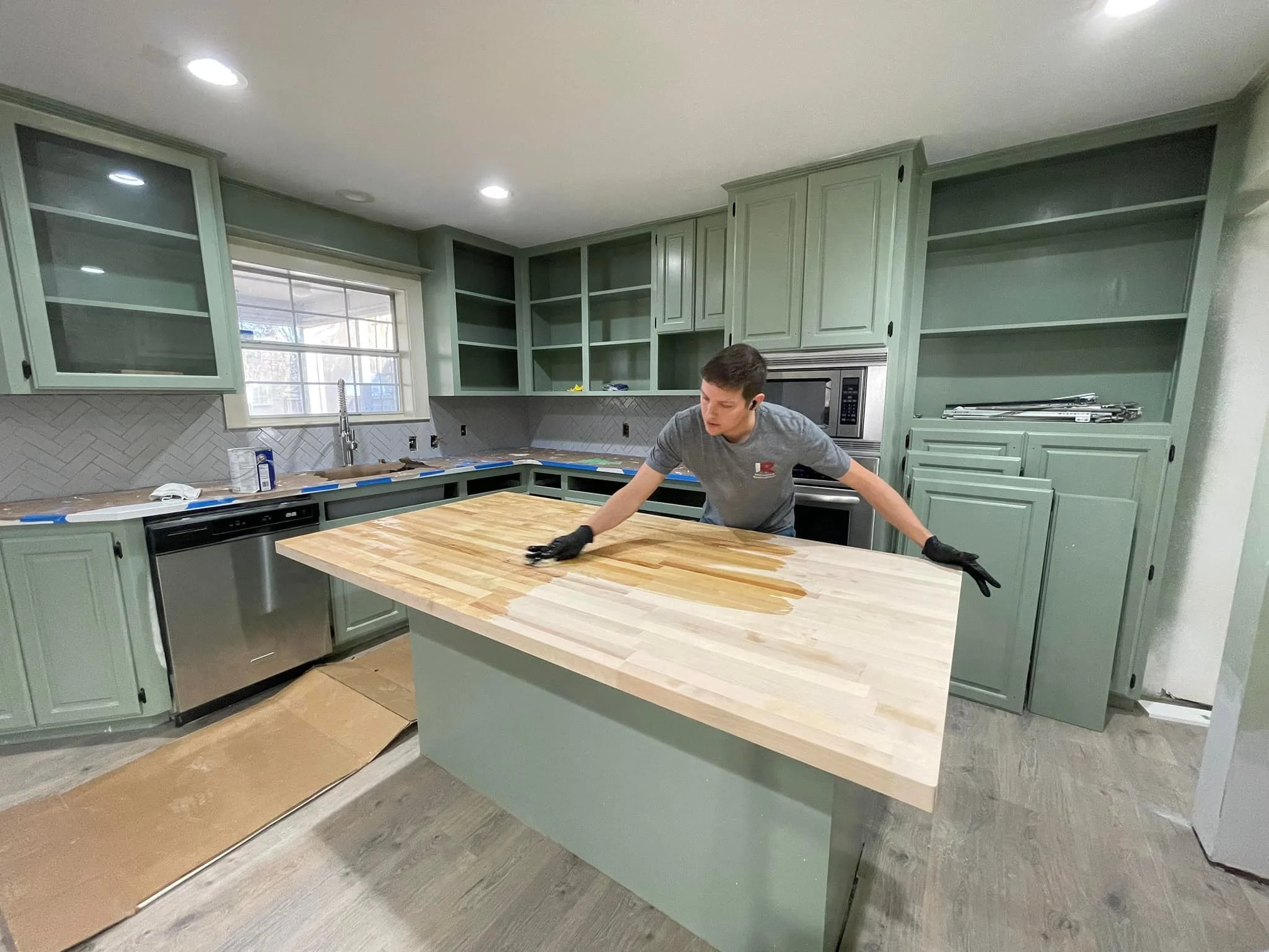 Justin Morrella, owner of Innovative Renovations, applying sealer to new bucher block countertop