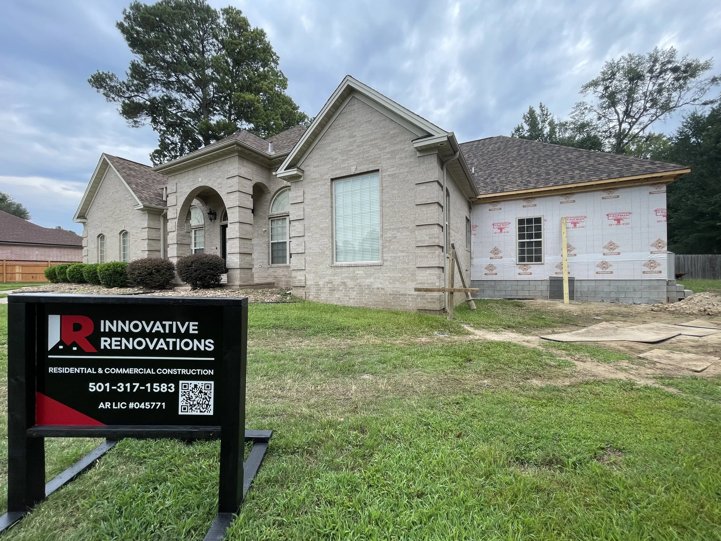 Home addition in progress in background with Innovative Renovations yard sign in the foreground