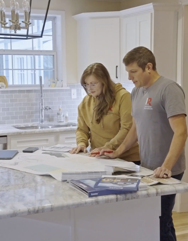 Owners, Justin and Kim Morrella, looking over plans at a table