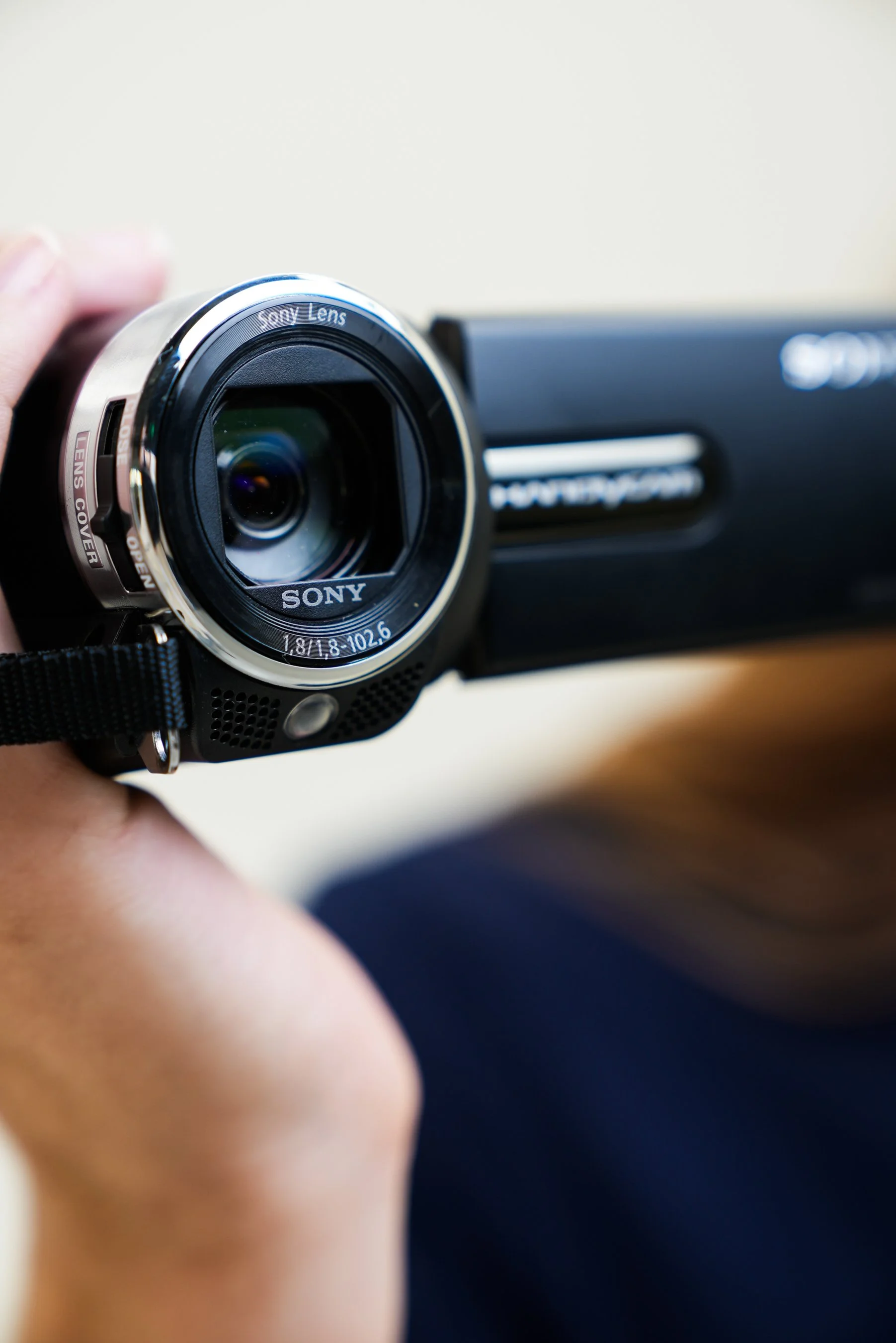 Een close-up van een hand die een Sony digitale camera vasthoudt.