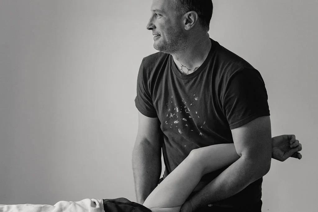 Tom Reeve, LMT, giving a massage to a person's arm on a massage table