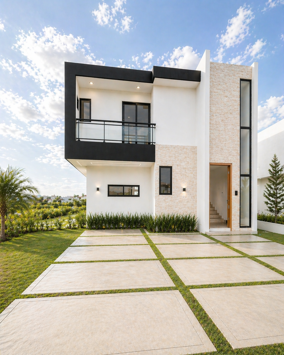 Modern two-story house with a black balcony, large windows, a small front garden, and a paved driveway under a partly cloudy sky.