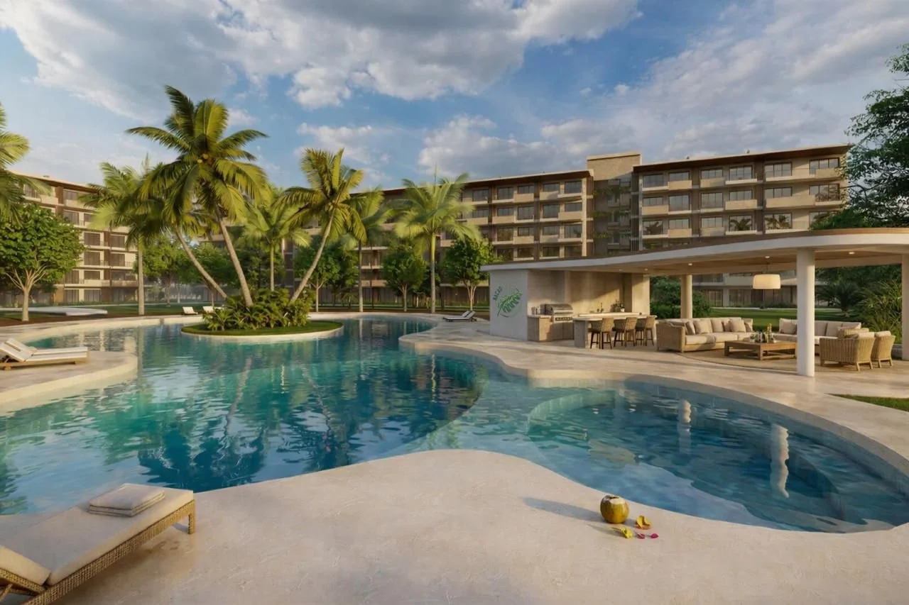 Luxury swimming pool area with palm trees, outdoor seating, and a bar in a modern residential complex.
