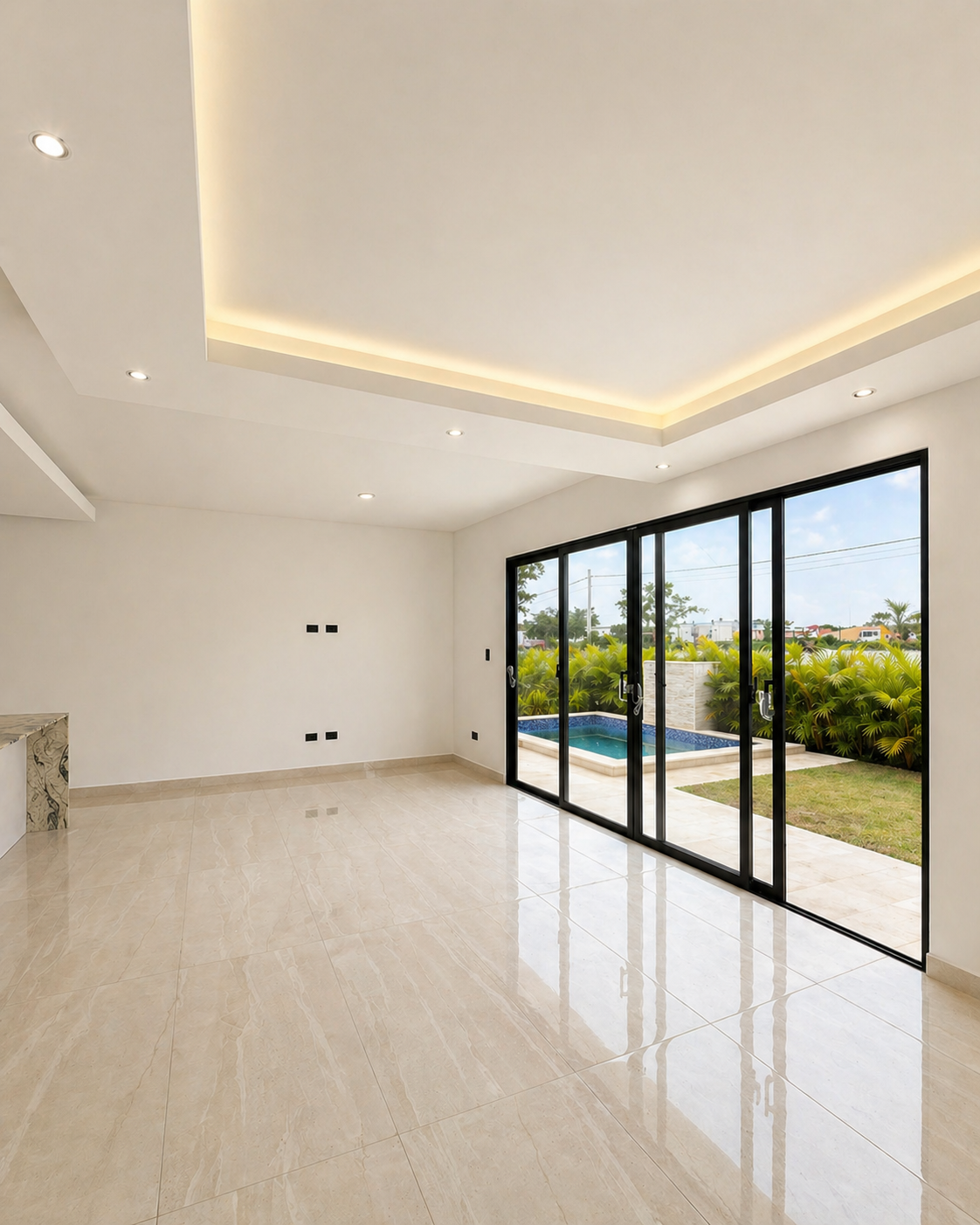 Empty modern living room with large glass sliding doors leading to an outdoor pool and garden.