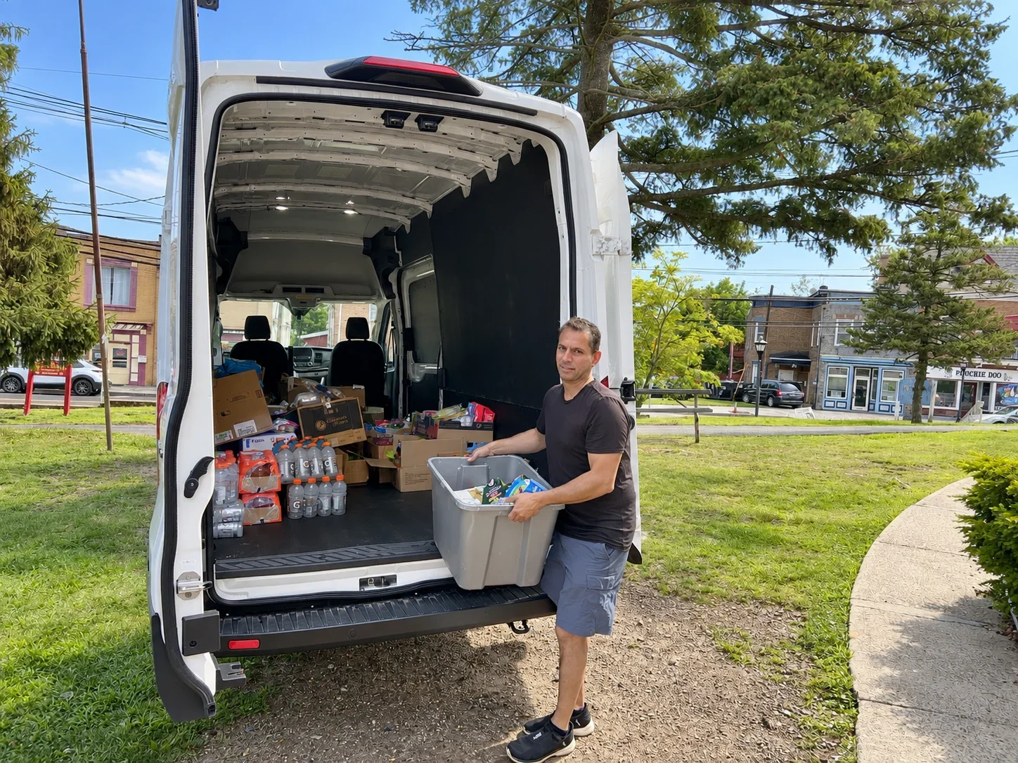 Volunteer loading food pantry supplies into a delivery van