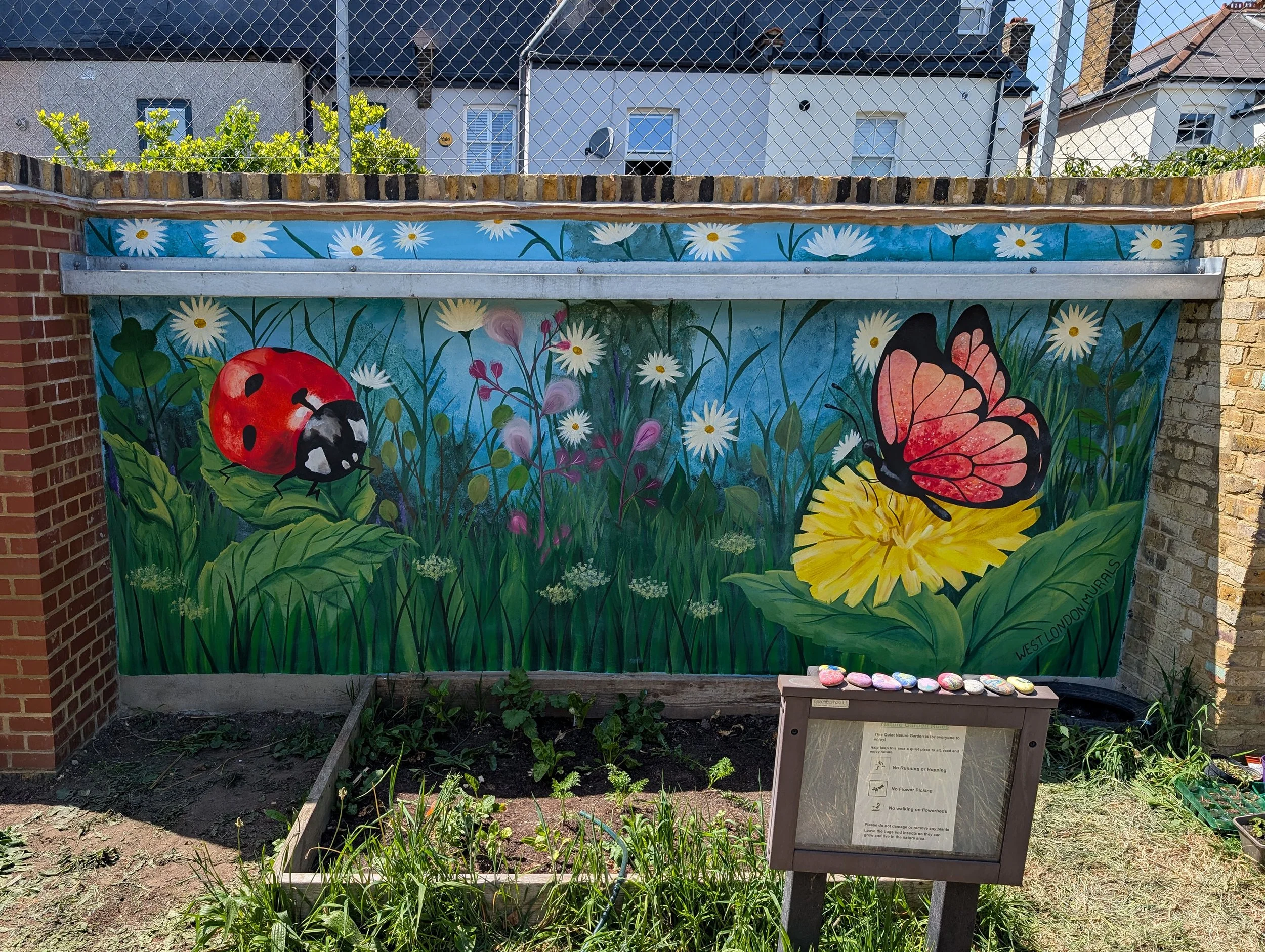 A colorful outdoor mural depicting daisies, a ladybug, and a butterfly on a garden wall in a school playground.