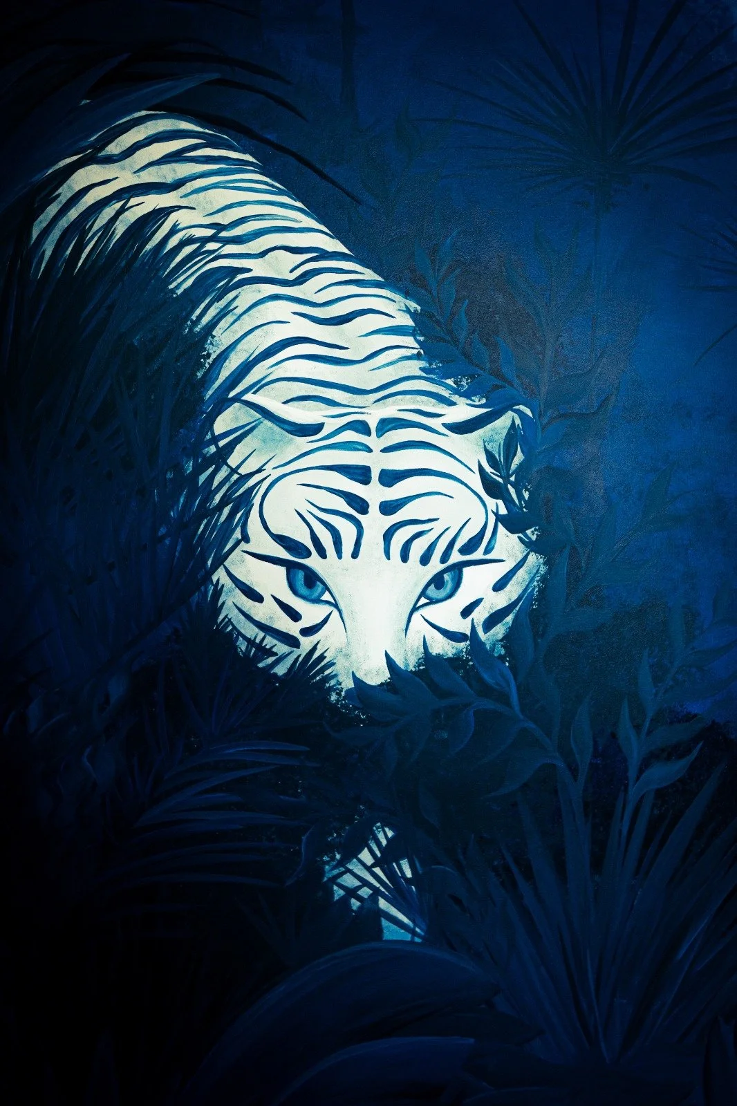 Indoor mural detail of white tiger in tropical jungle foliage illuminated in blue light.