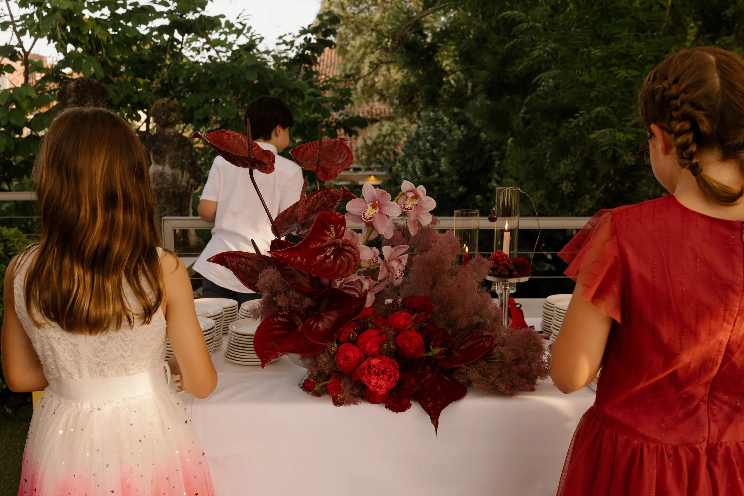 Atmospheric welcome cocktail party on a Venetian rooftop terrace with traditional cicchetti and bordeaux details.