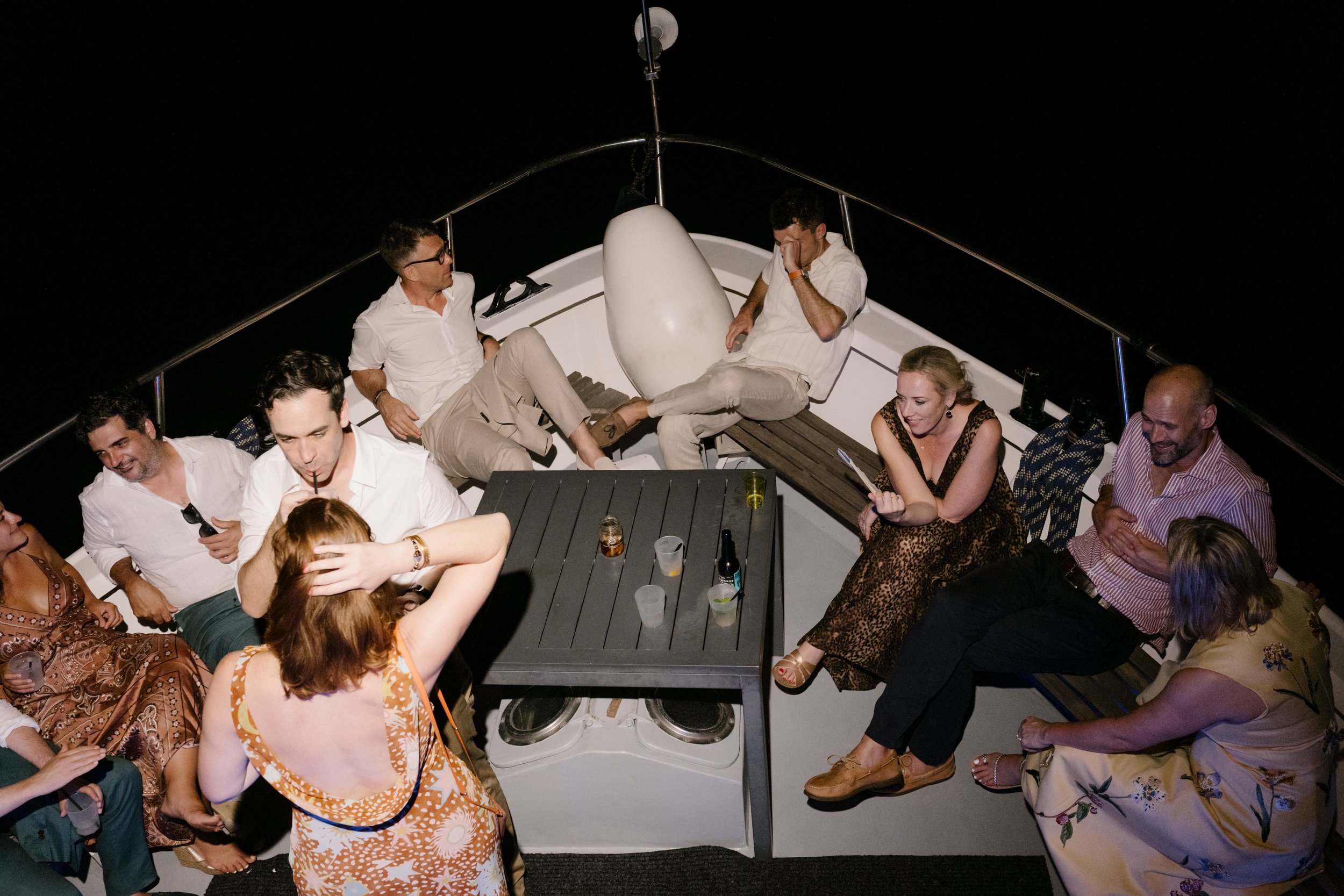 Guests celebrating on a private boat cruise returning to Venice across the lagoon at night.