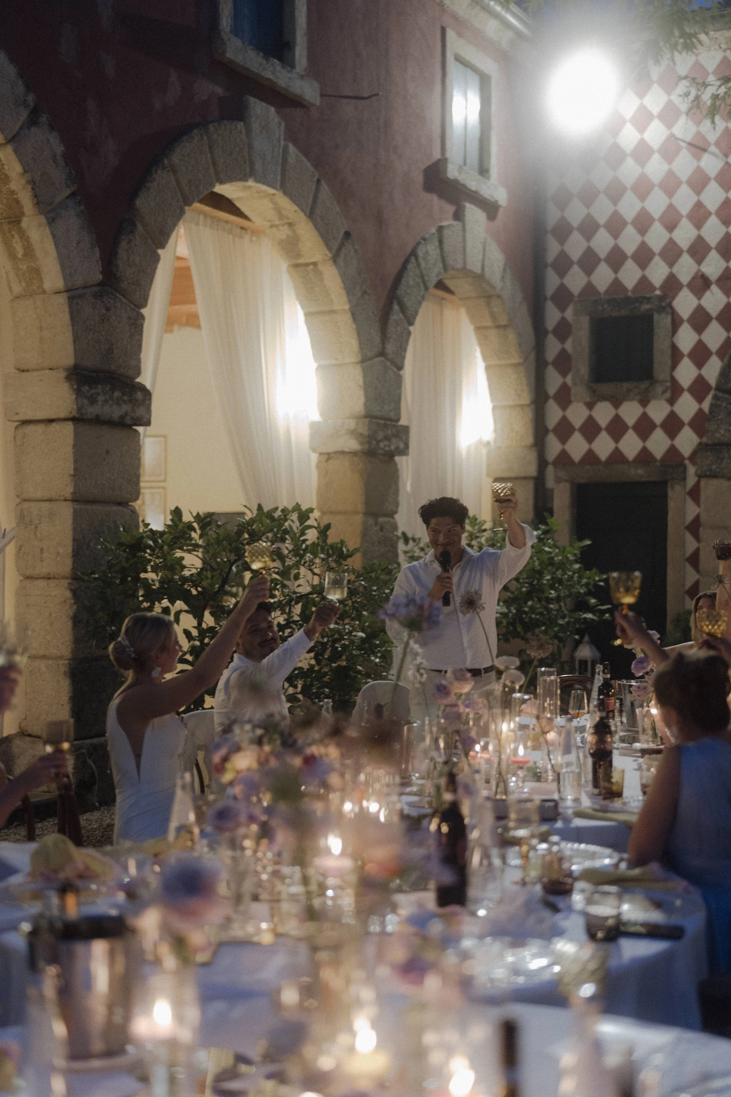 Atmospheric outdoor wedding dinner setup with candles under the stars in Verona