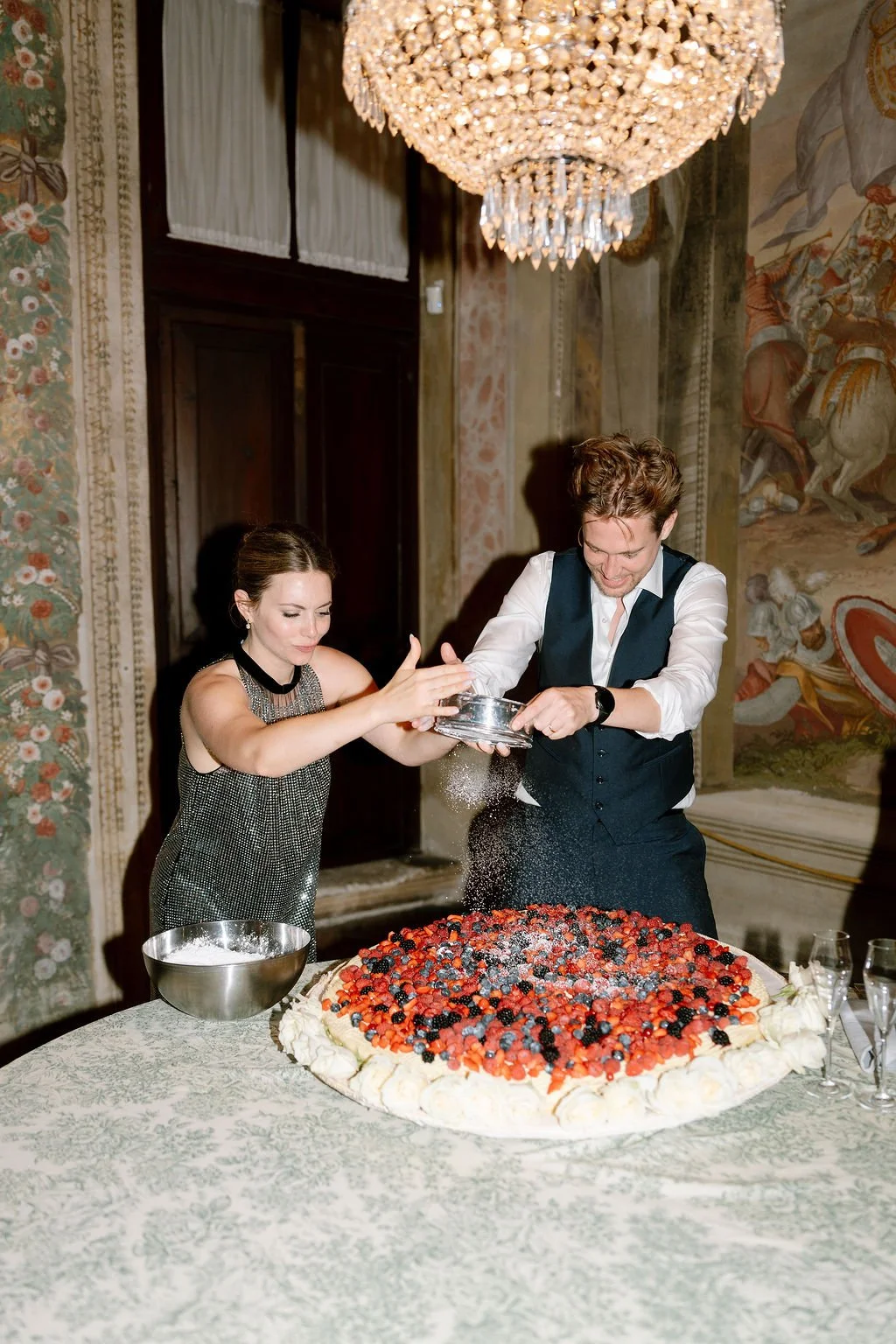 couple putting sugar on cake on wedding day