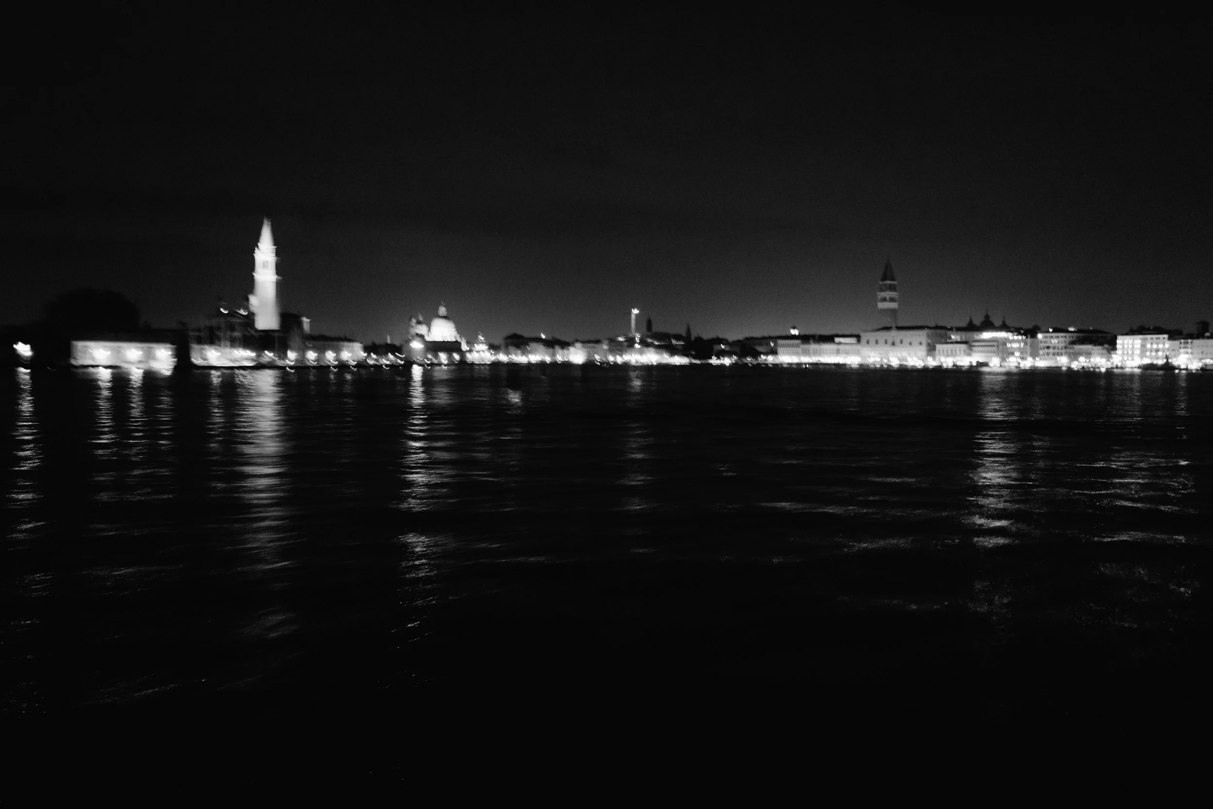 Private boat cruise returning to Venice across the lagoon at night.