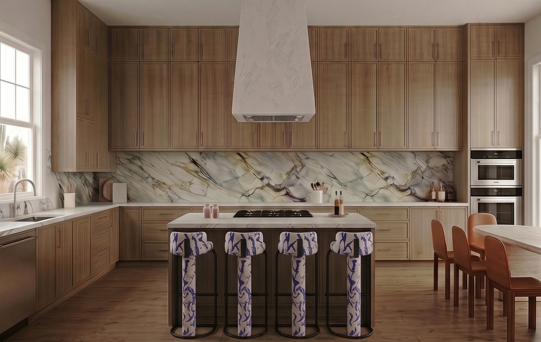 Modern kitchen with light wood cabinets, marble backsplash, island with four patterned barstools, marble countertops, and dining area with orange chairs.