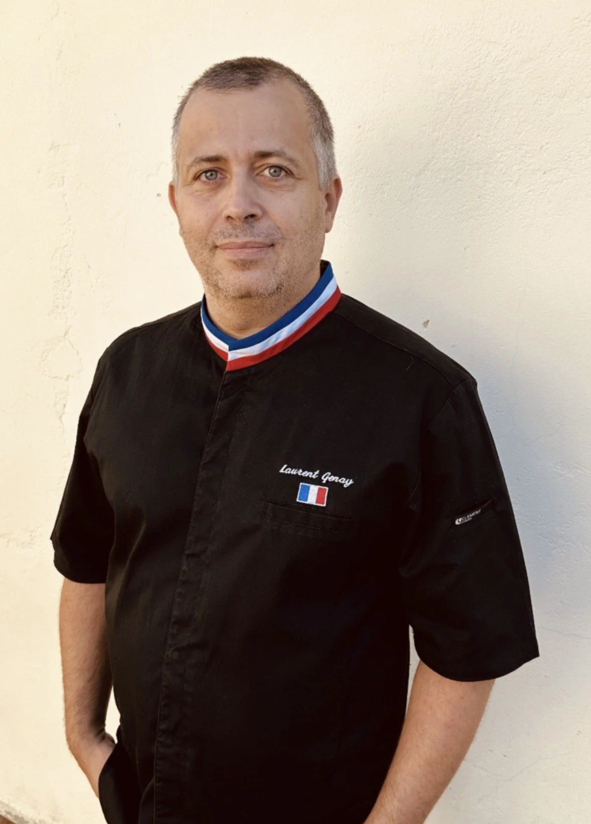 Laurent Genay, Opticien, portant une veste noir avec un col aux couleurs du drapeau français, meilleur ouvrier de France lunetier,  lunetterie française.