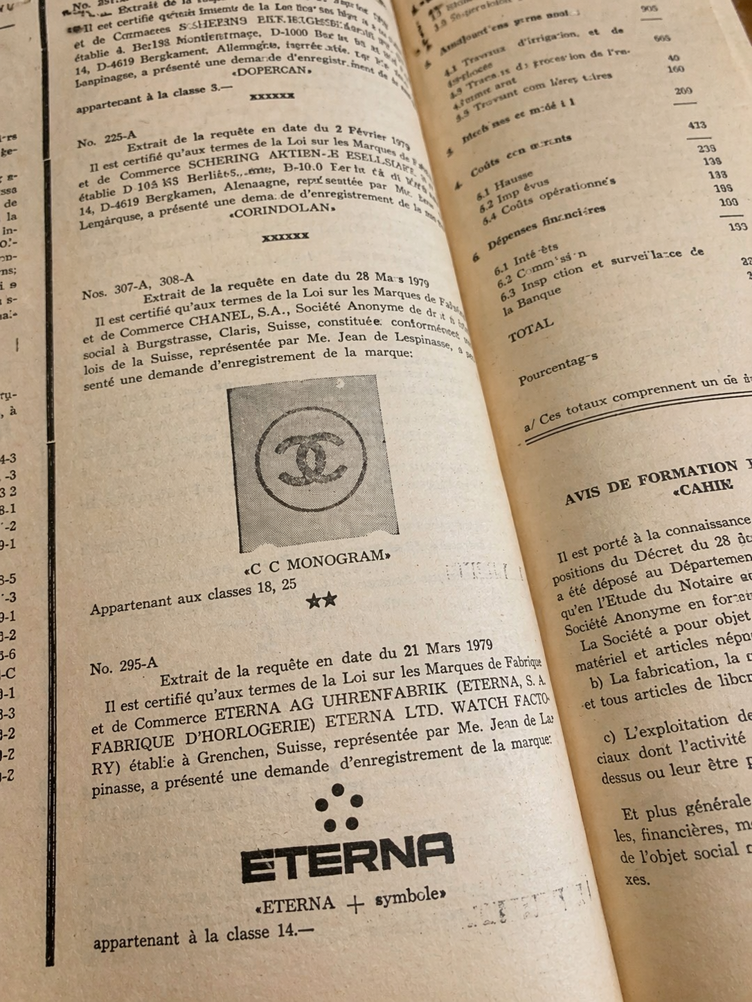 An open book displaying legal or official documents, including stamped logos and text in French, with visible pages and printed content.
