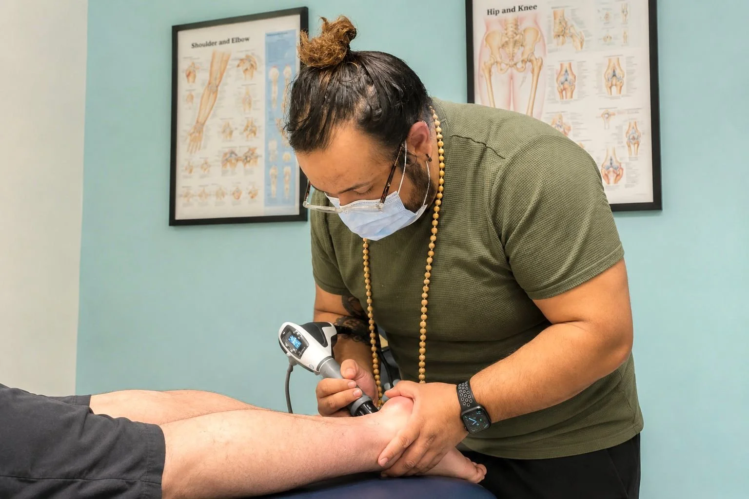 An Osteopath and Physiotherapist providing Shockwave therapy for Achilles Tendinopathy, in Hayes West London
