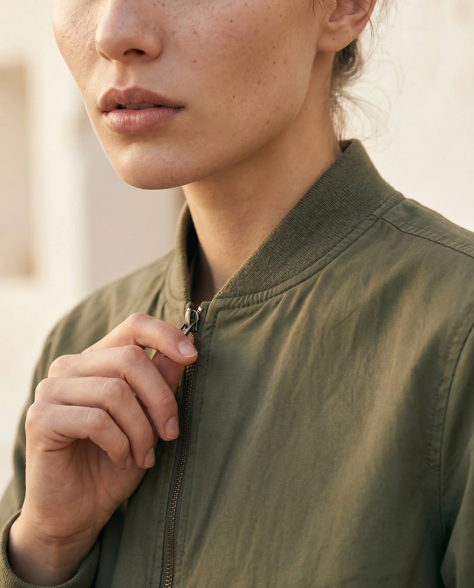 Detalhe editorial de moda com casaco verde, criado para destacar textura, styling e identidade visual da marca.