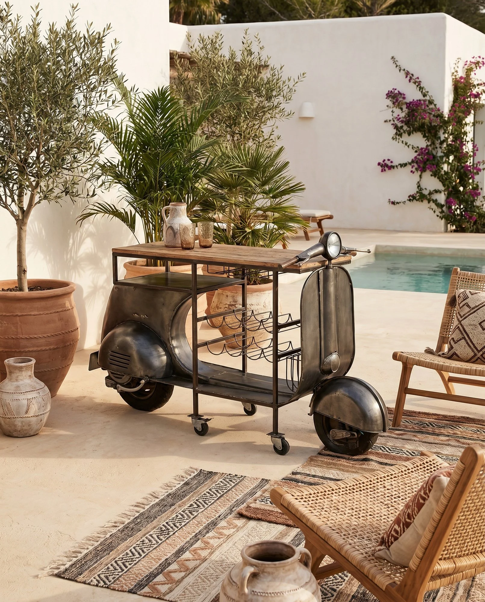 Imagem editorial de decoração com móvel bar num ambiente de terraço mediterrânico, criada para comunicação visual de marca.