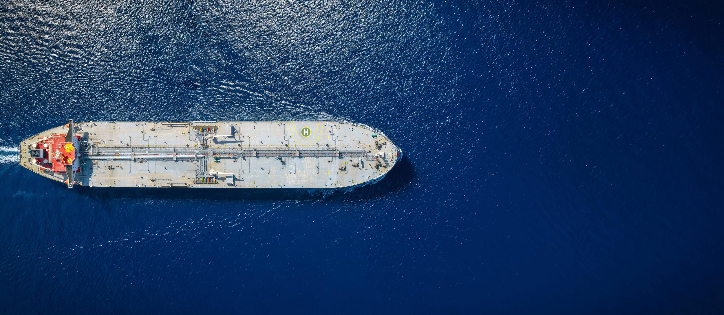 Aerial view of a large cargo ship sailing in the open ocean.