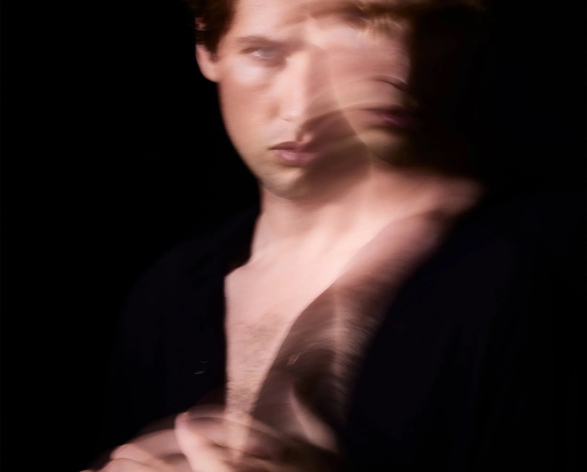 Blurry close-up of Filip Clements' face against a dark background, with motion effect.
