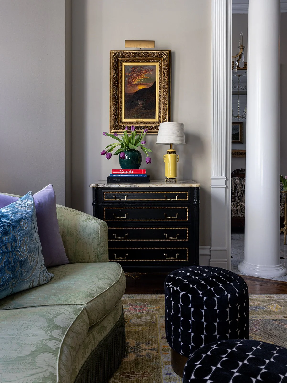 eclectic living space with custom green couch and antique marble top credenza.