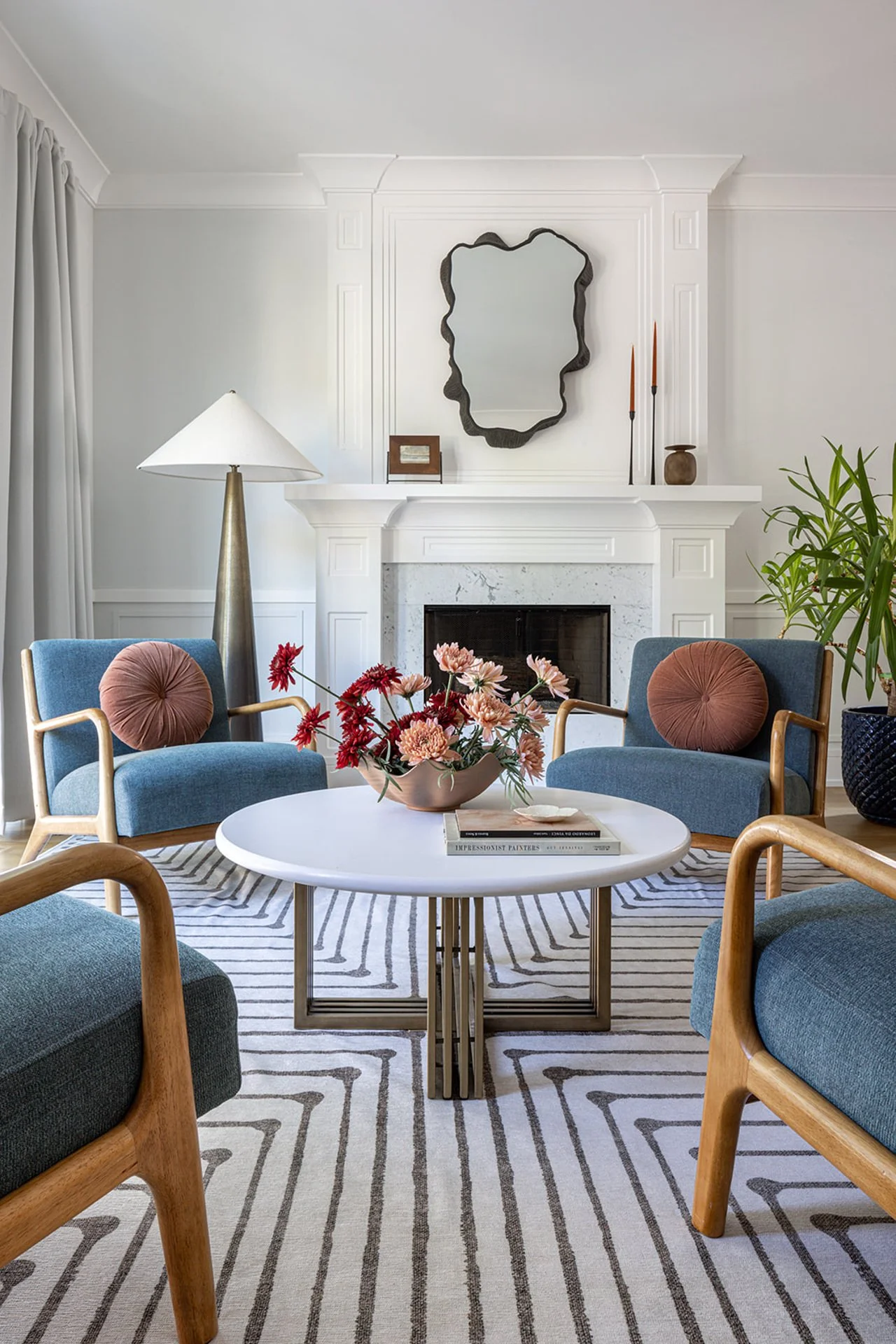 Living space with blue cushioned arm chairs and striped rug.