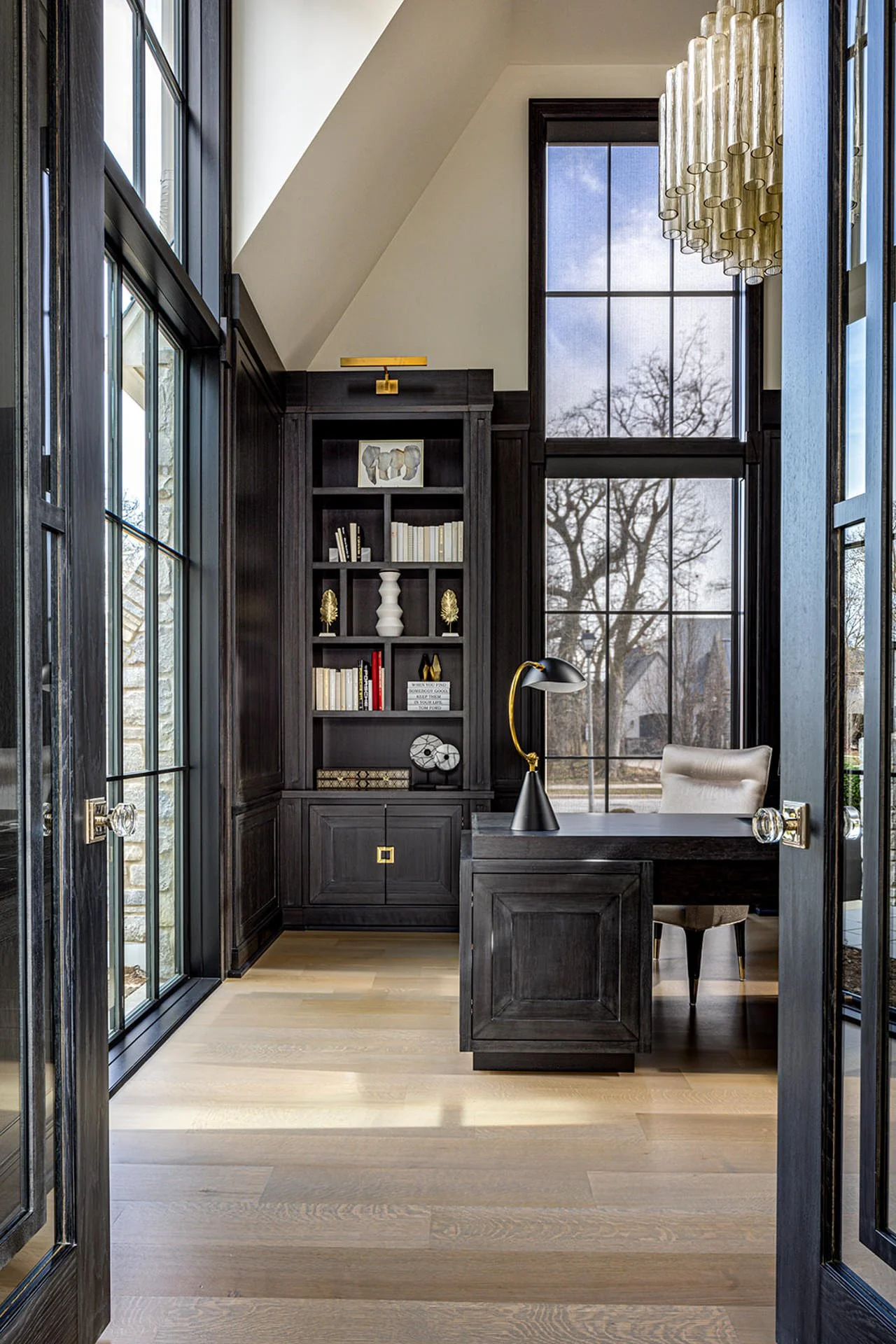 home office with black built in furniture and matching desk.