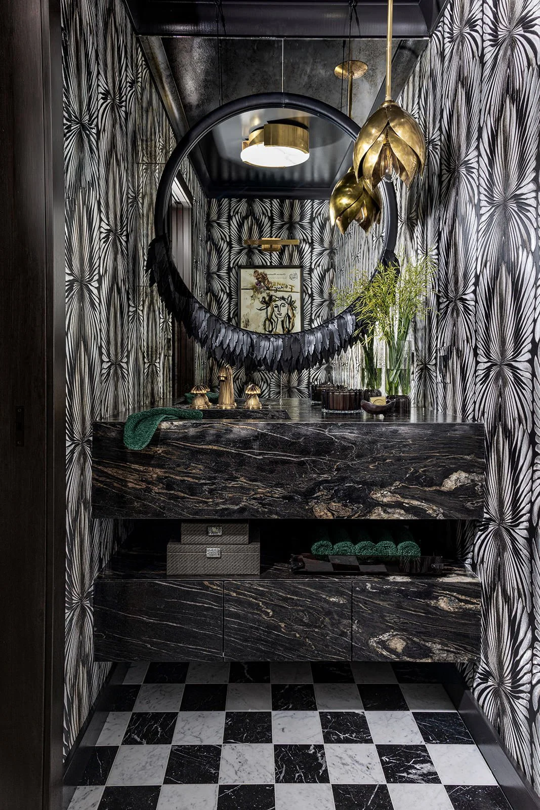 Decorative bathroom with black and gold accents, floral wallpaper, black marble sink, and checkered black-and-white floor.