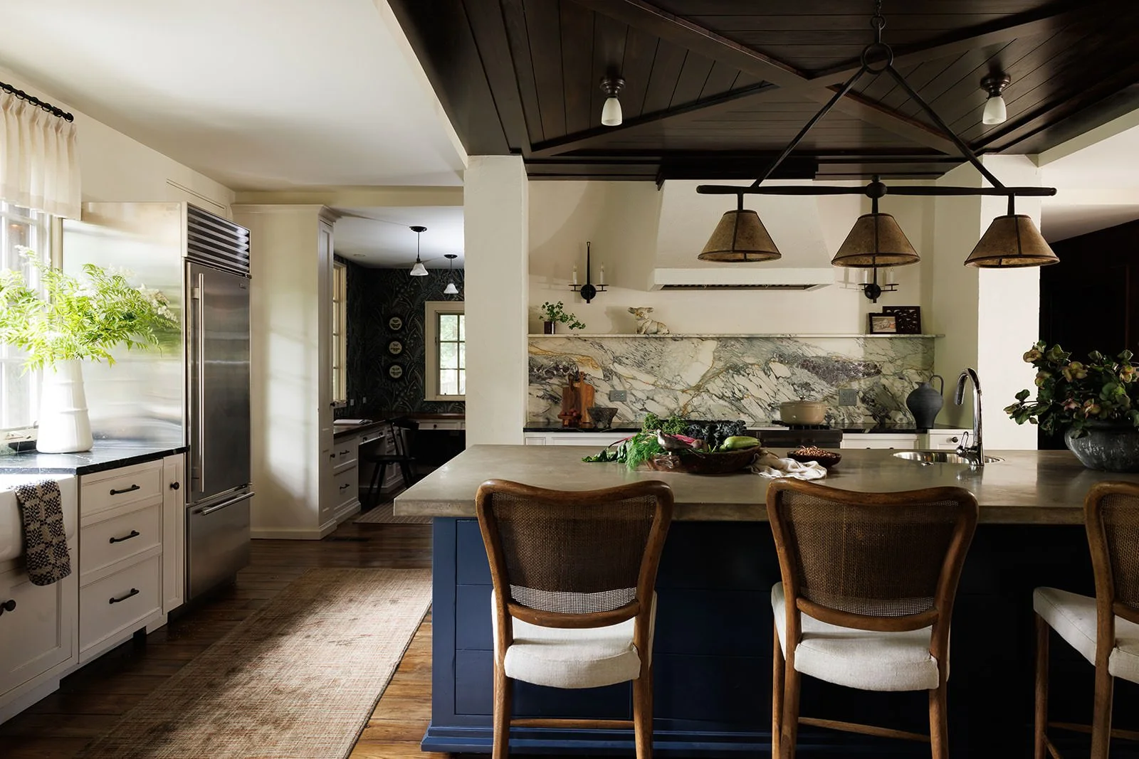 dark wood ceiling in this custom kitchen with navy kitchen island paired back to white cabinets