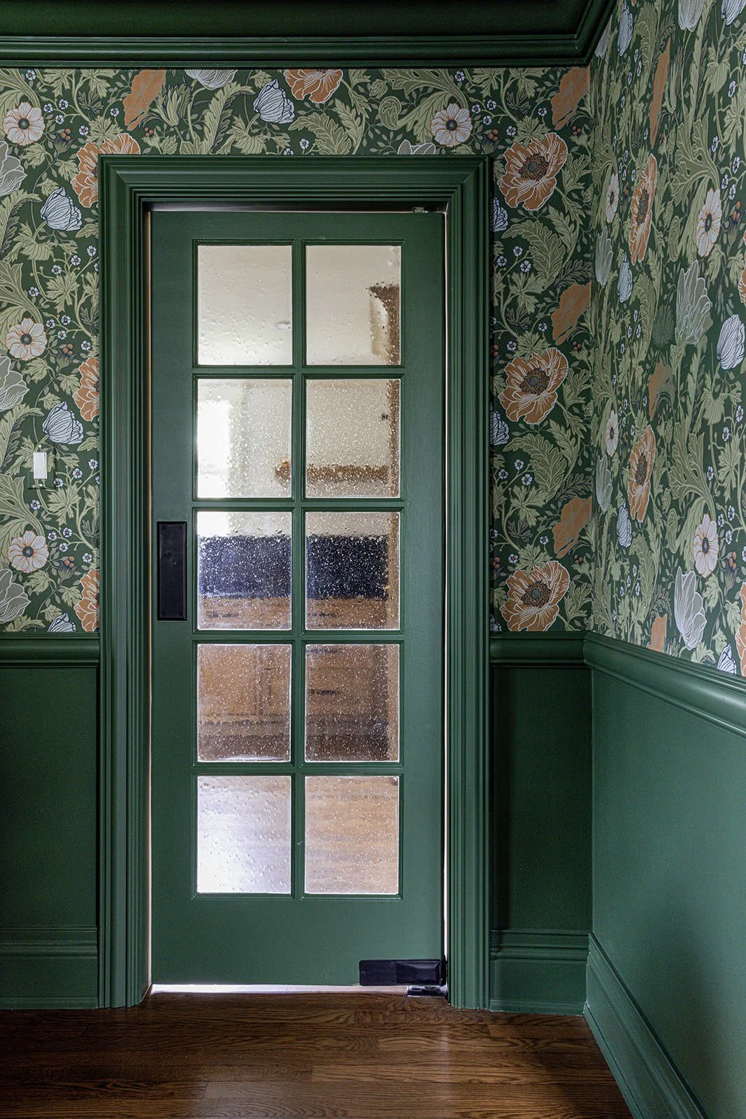 floral wallpaper and green paint to add high impact to this interior design space