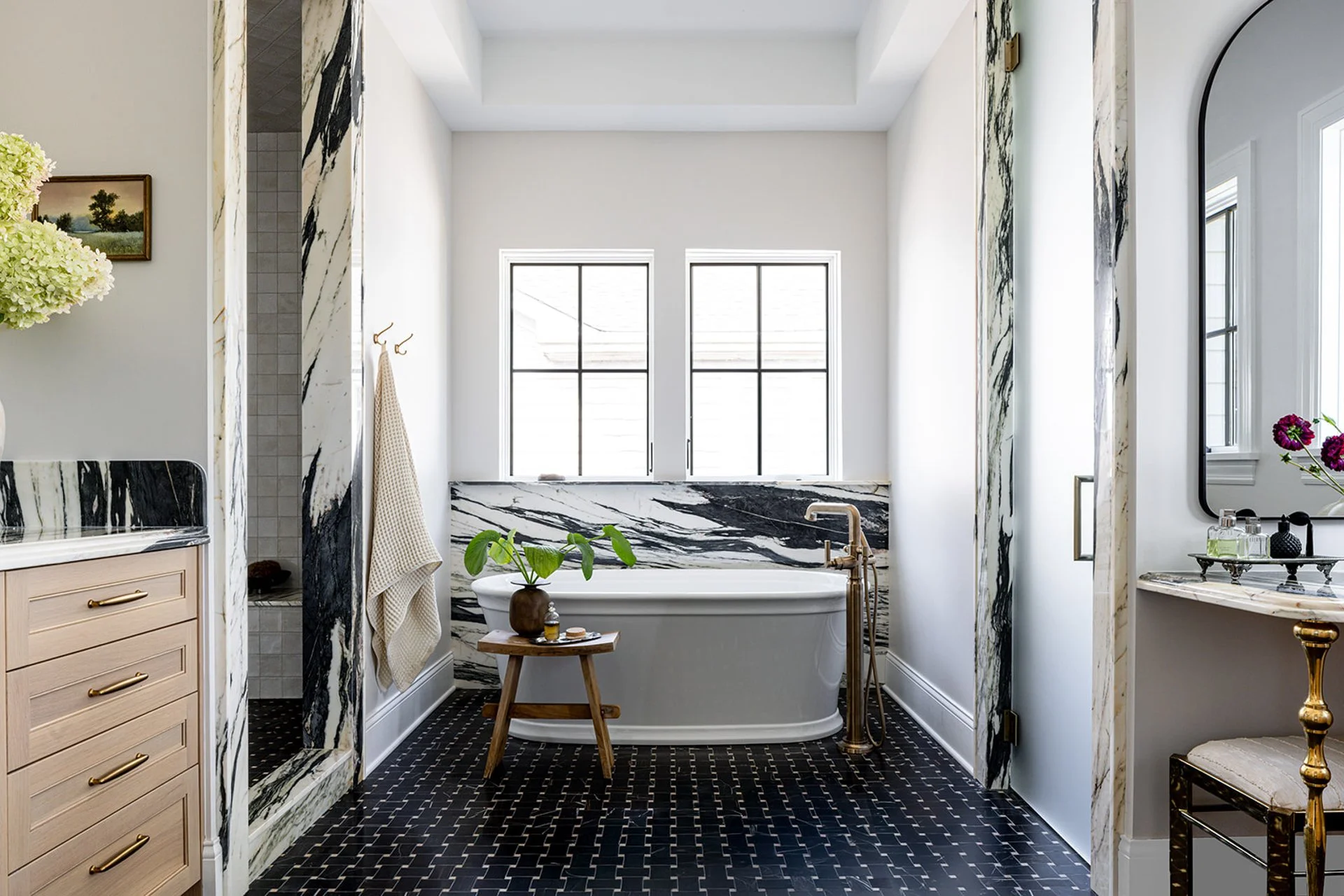 luxury primary suite with stand alone tub and granite slab accents