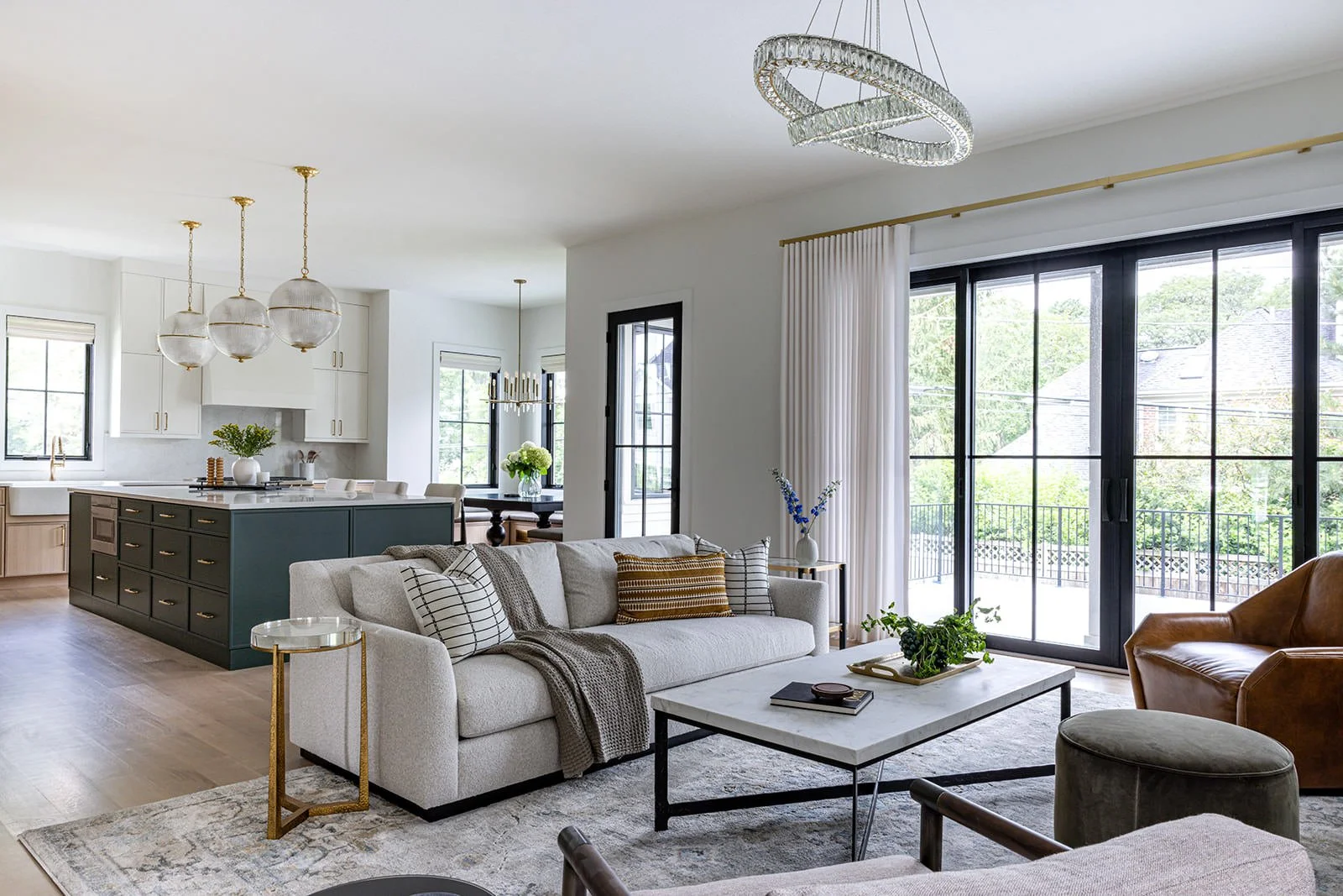 open concept kitchen and living room design with black accents, soft white details and lots of natural light