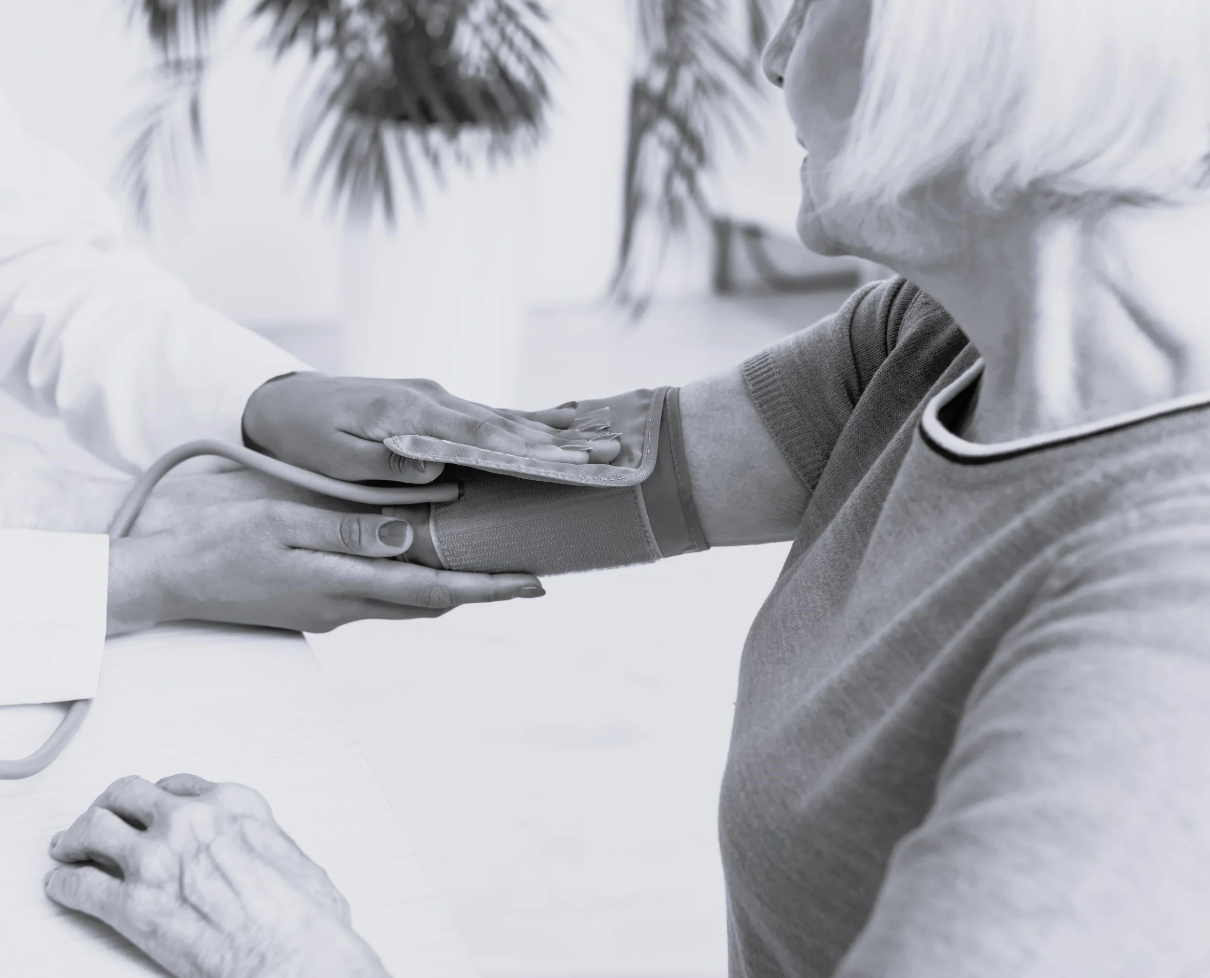 Close-up of a healthcare worker taking a patient's blood pressure with a sphygmomanometer.