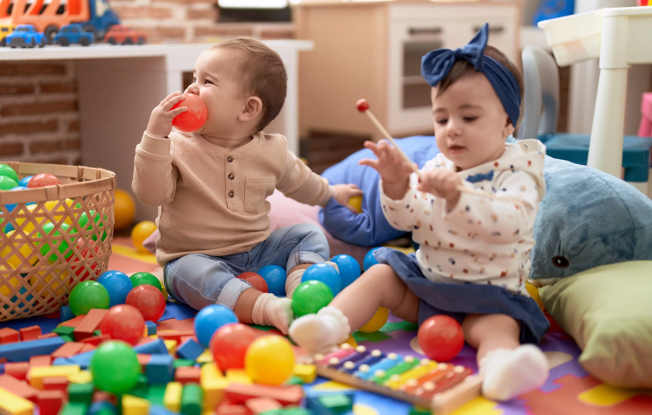 two-toddlers-playing-with-balls-xylophone-sitting-floor-kindergarten.jpg