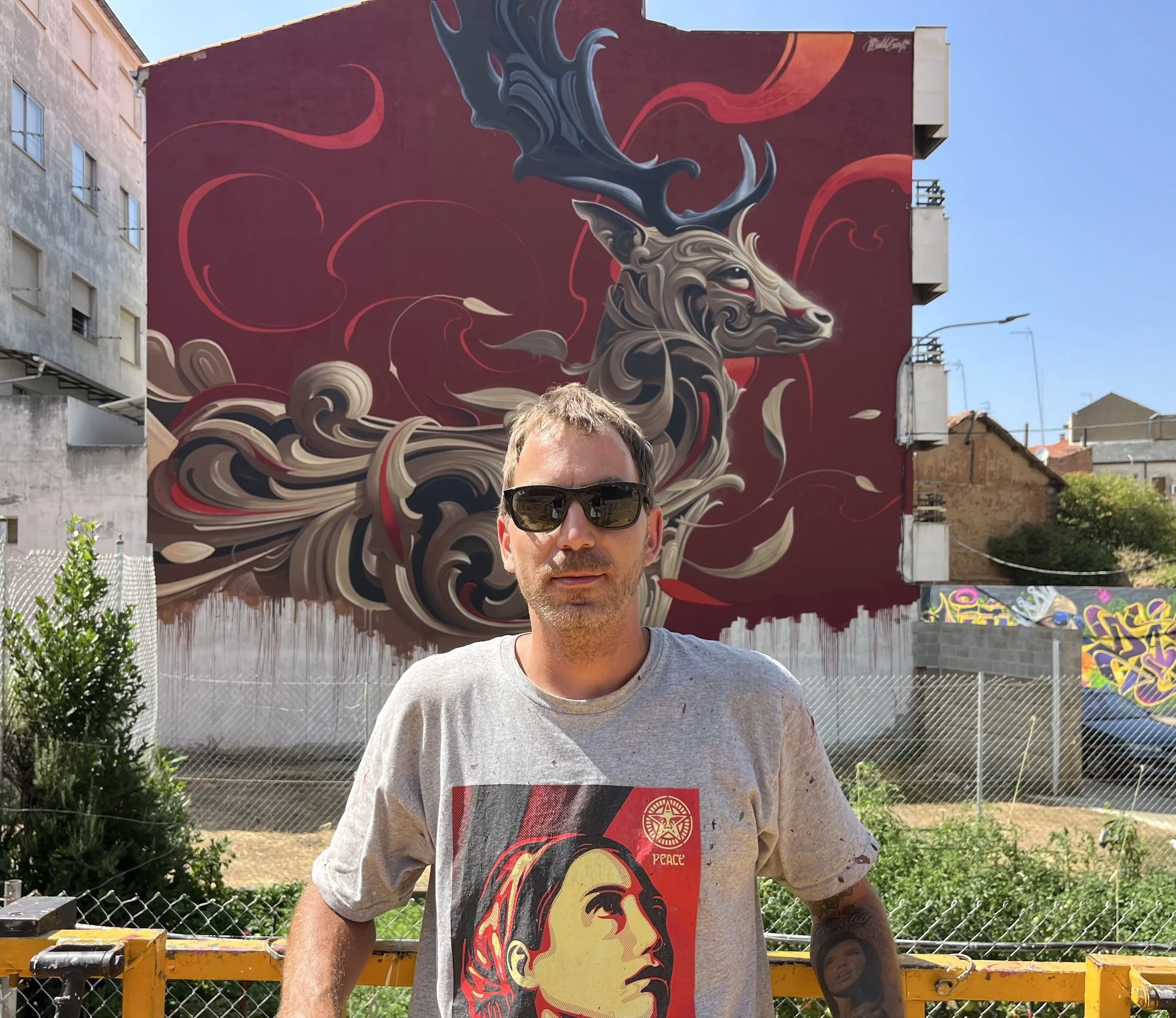 Spanish award-winning artist Bublegum (Tirso Paz) posing with his artwork. A world-class muralist with an international career, known for creating the Ornamental Style and blending fine art with monumental urban interventions.