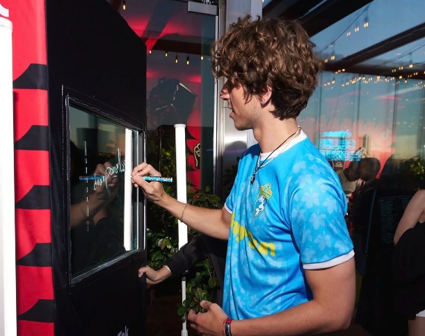 Guest participating in an interactive Scribble Booth photo and video activation at a branded event.