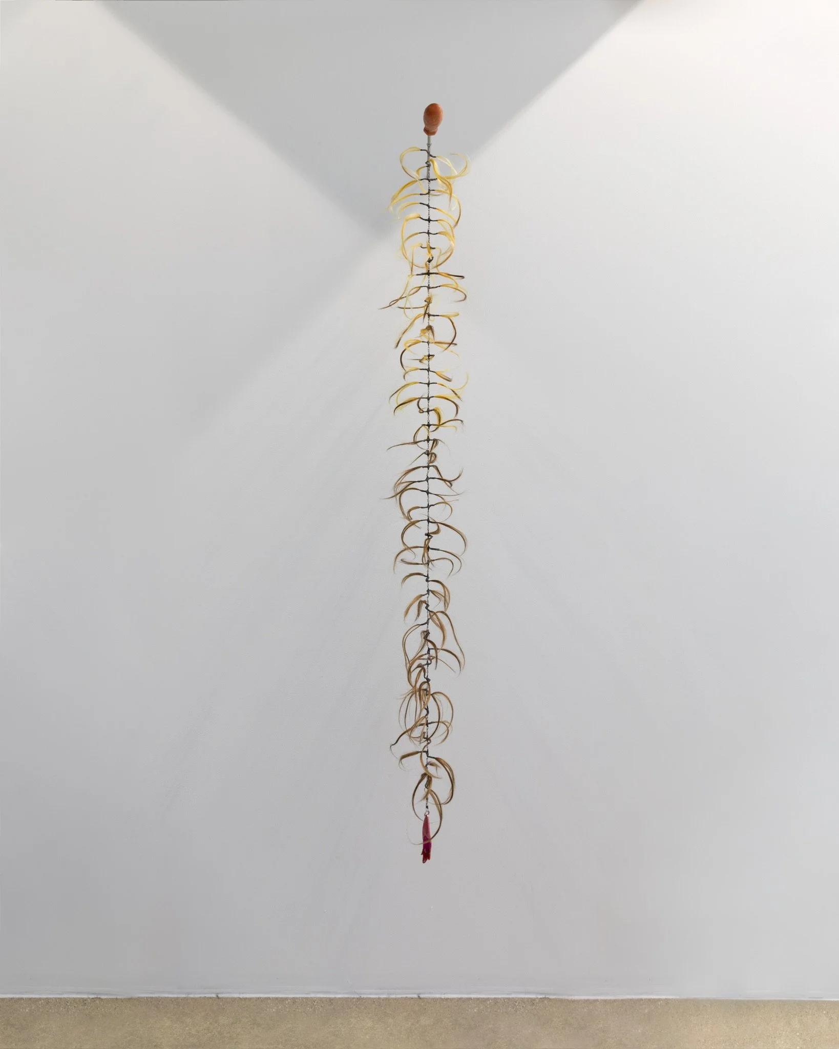 "Siren Call". Beeswax, human hair, thread, encaustic pigment, fishing lure, metal leaf, beads, steel. 60” H x 8” W x 60” D. 2026.