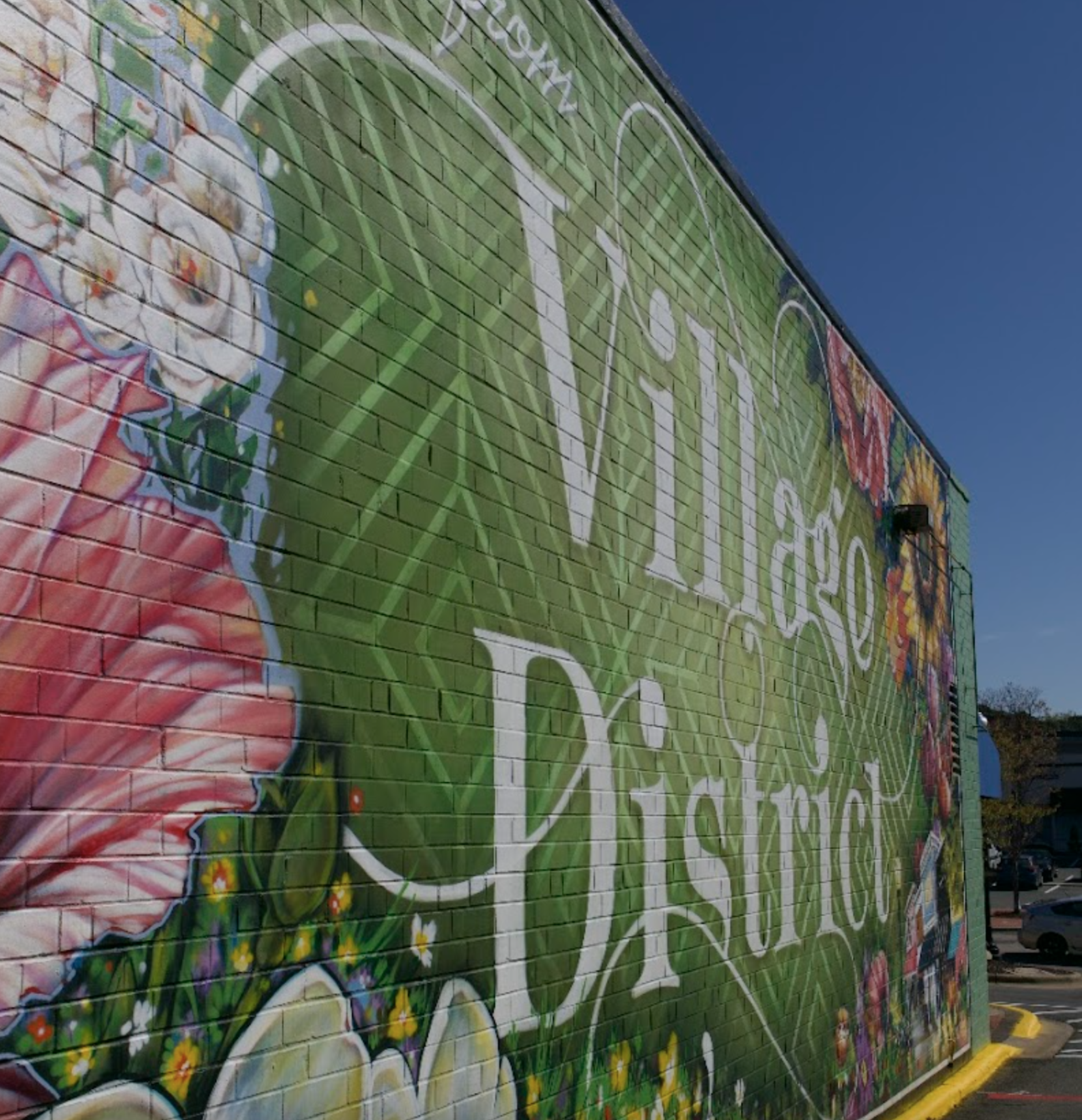 Colorful mural on a brick wall with flowers, leaves, and text that reads 'Hoping for a better tomorrow.'