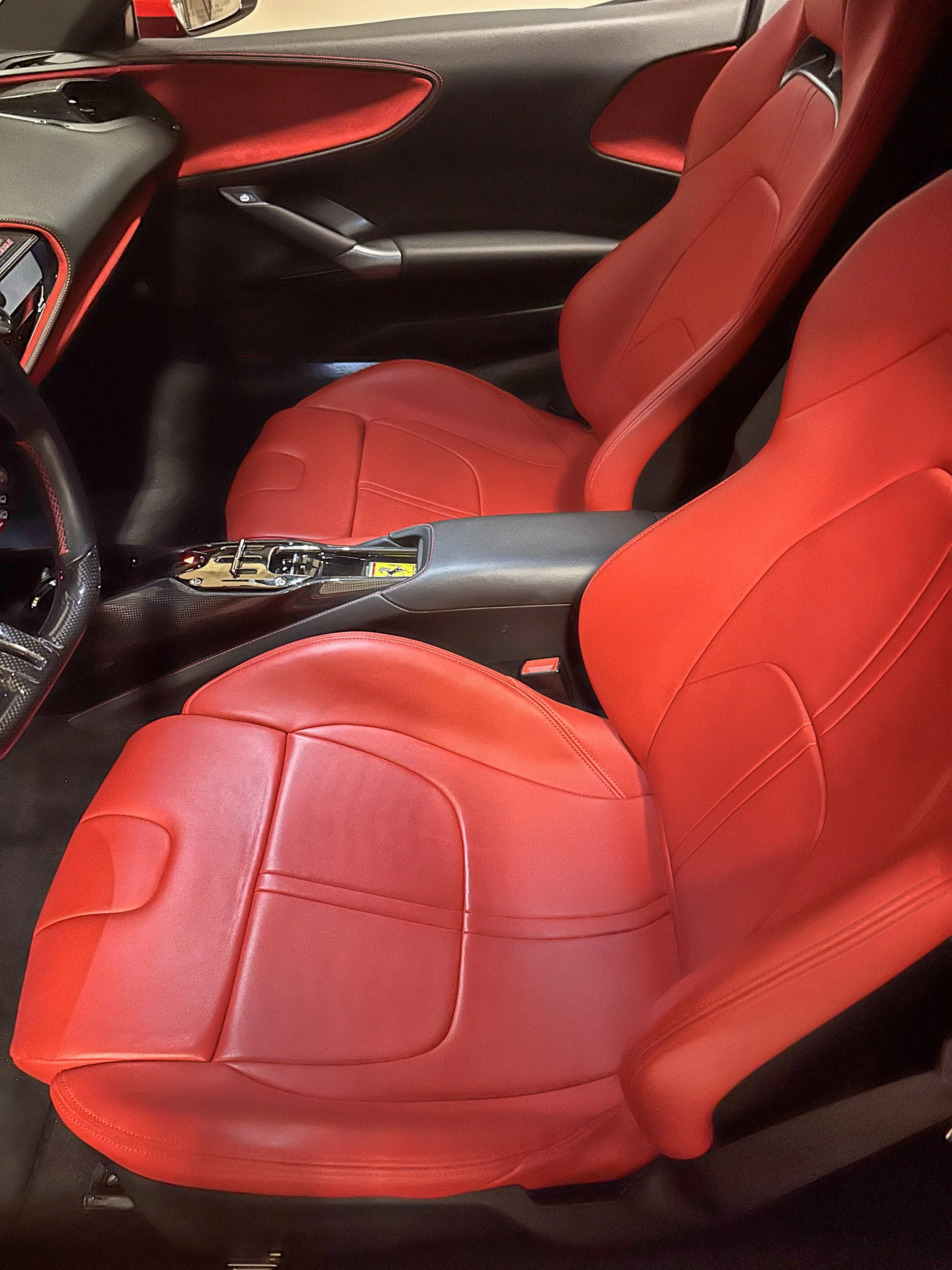 Interior of a sports car with red leather seats, black dashboard, and gear shift.