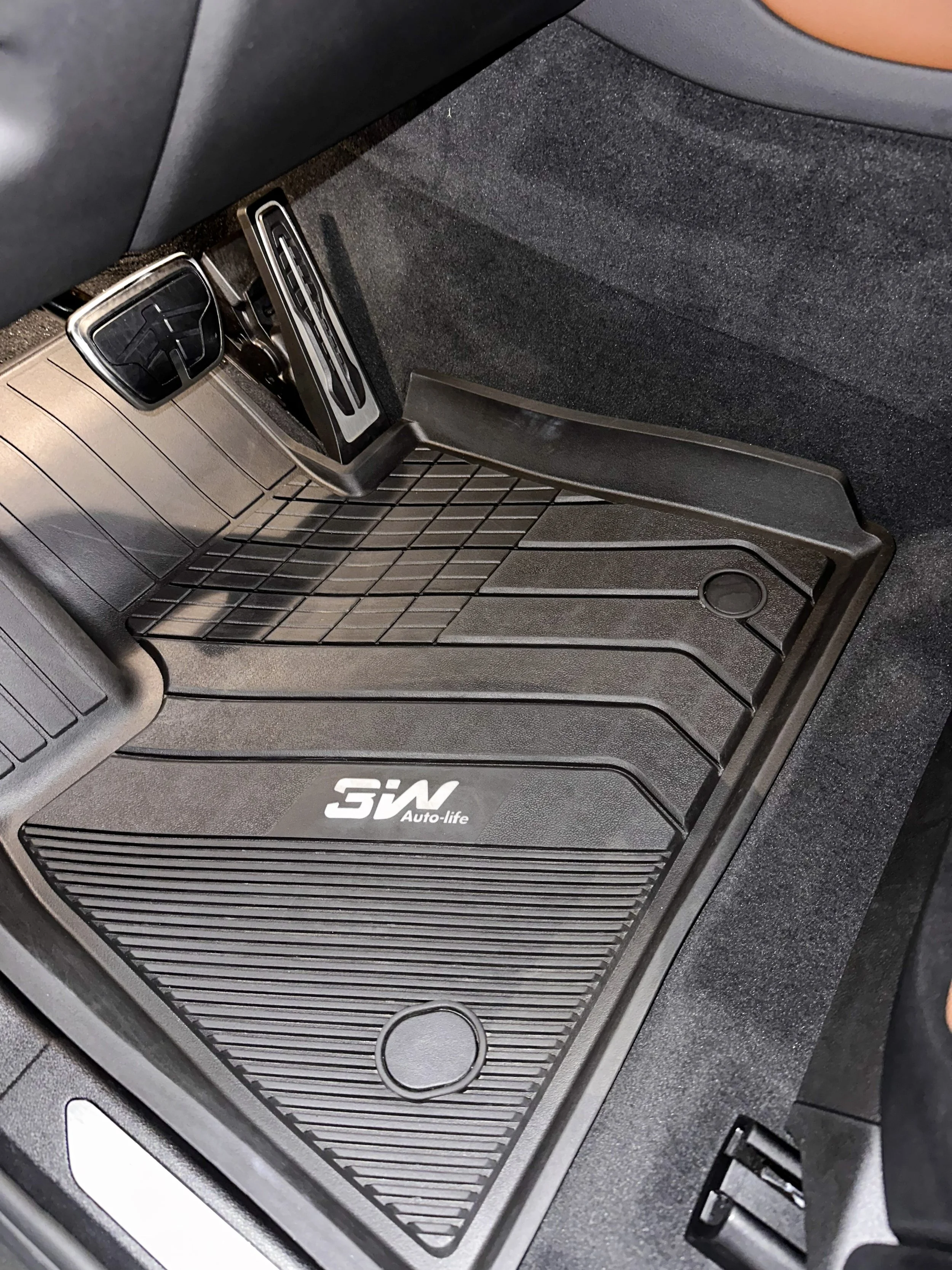 Car floor mat with a metal grid, a branded logo 'SV Auto-life', and around, compartments and vents, inside a vehicle.
