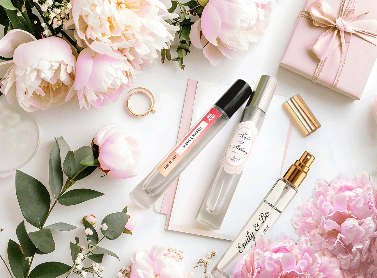 Personalized fragrance bottles styled with pink flowers and gifting details.