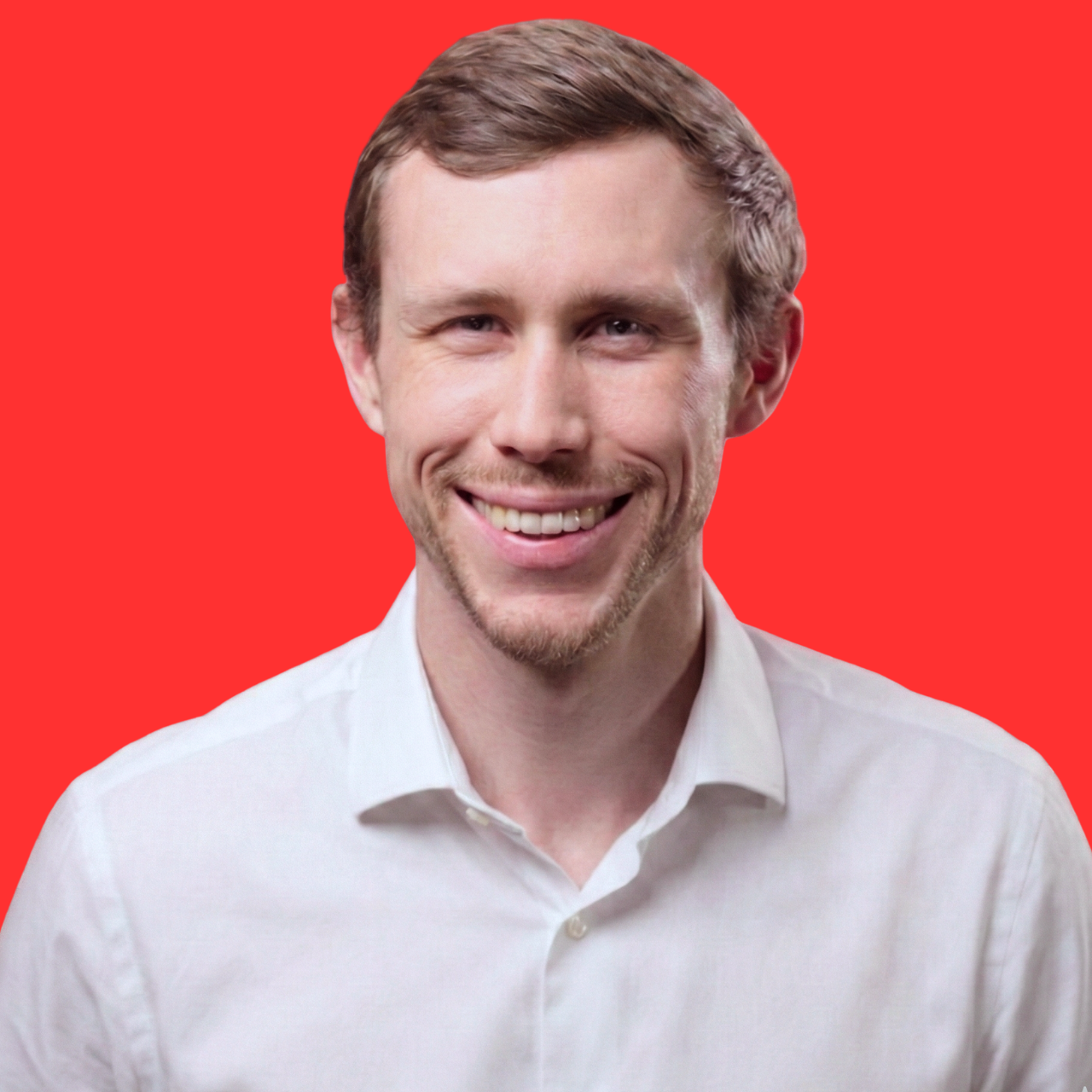 A young man with light brown hair styled to the side, smiling, wearing a white collared shirt, against a bright red background.