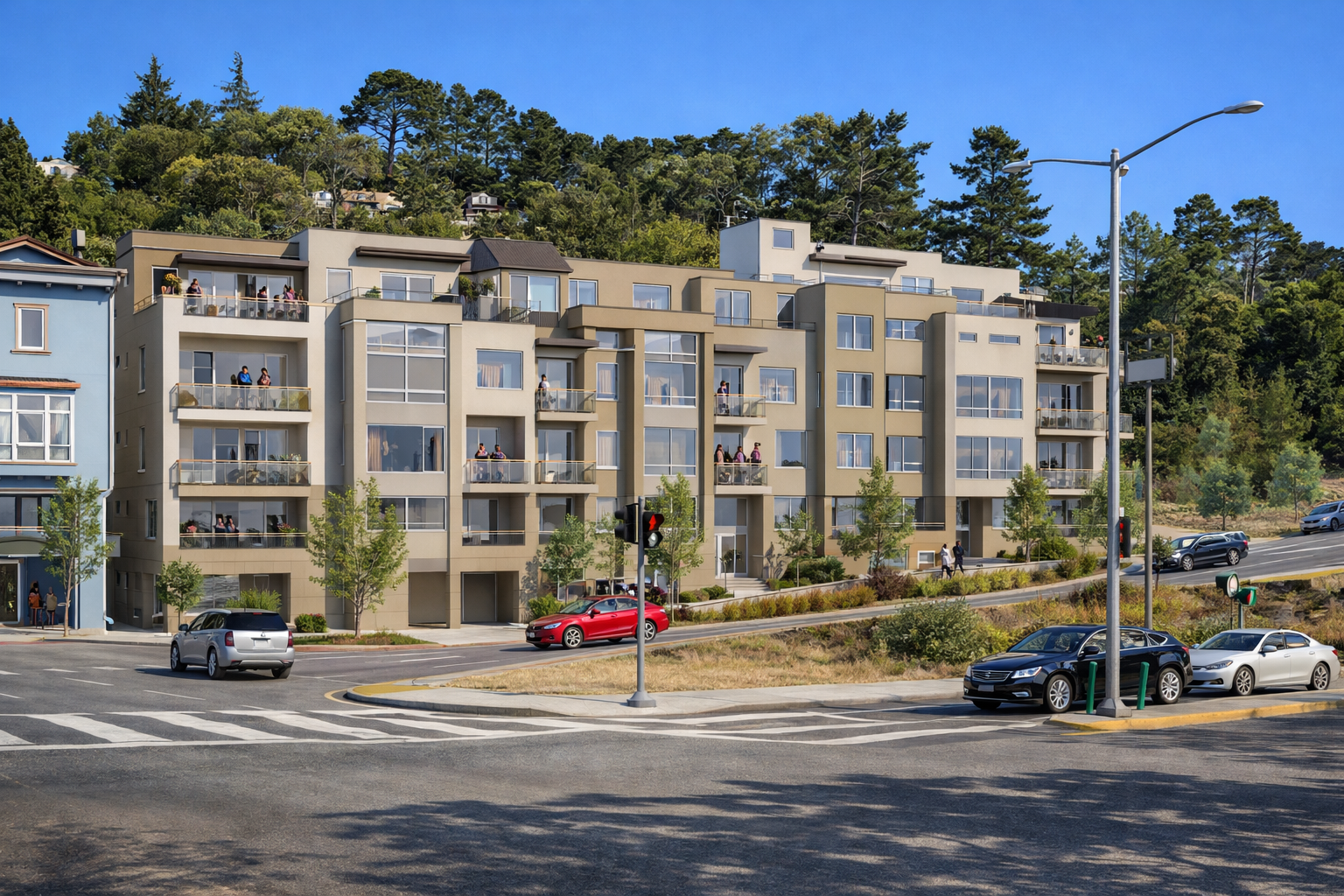 Multi-story apartment building with balconies, cars parked in front, trees, and a hillside with more houses in the background under a clear blue sky.