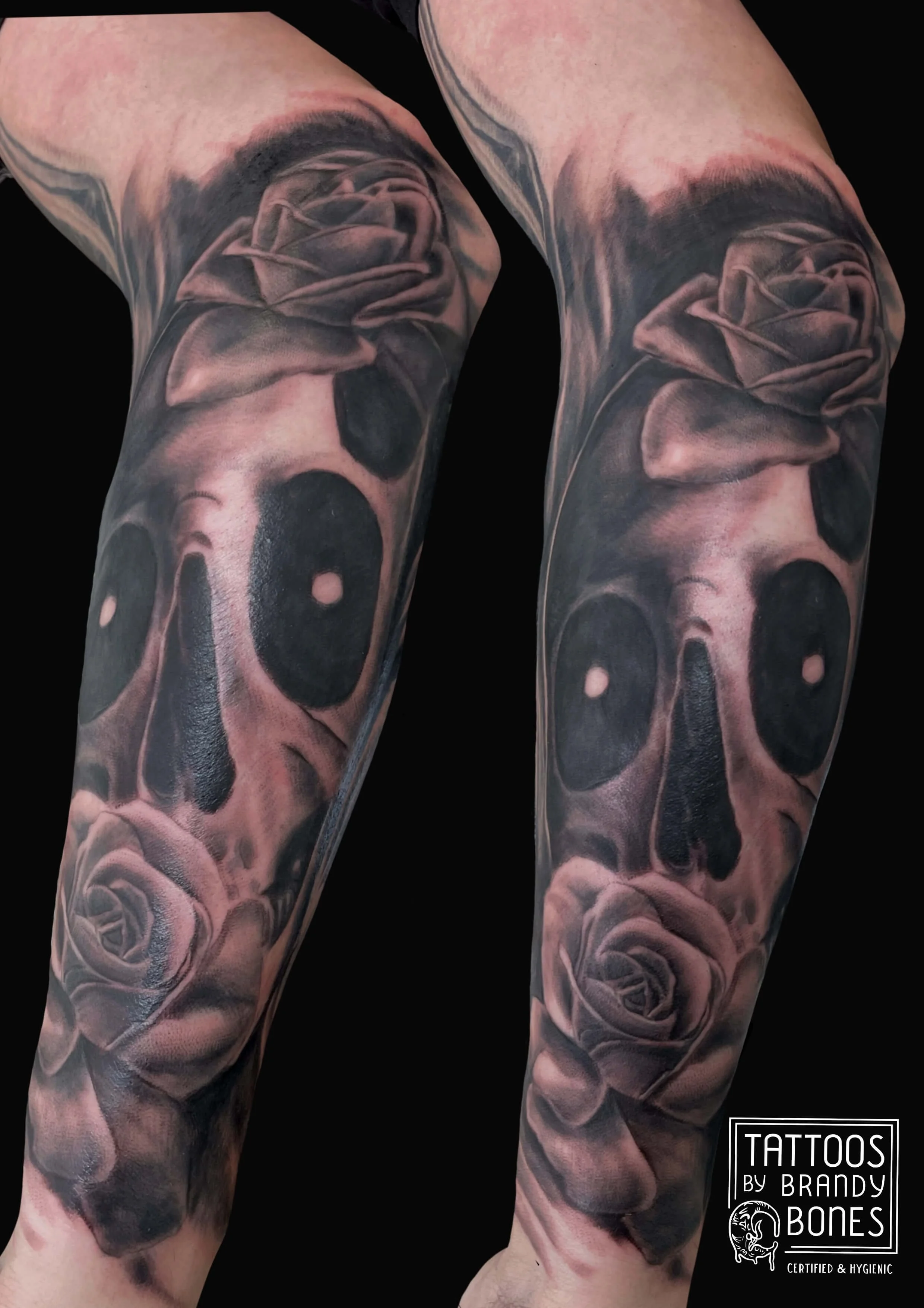 Tattooed arms with realistic black and gray rose and skull designs, with shading and fine details, on fair skin.