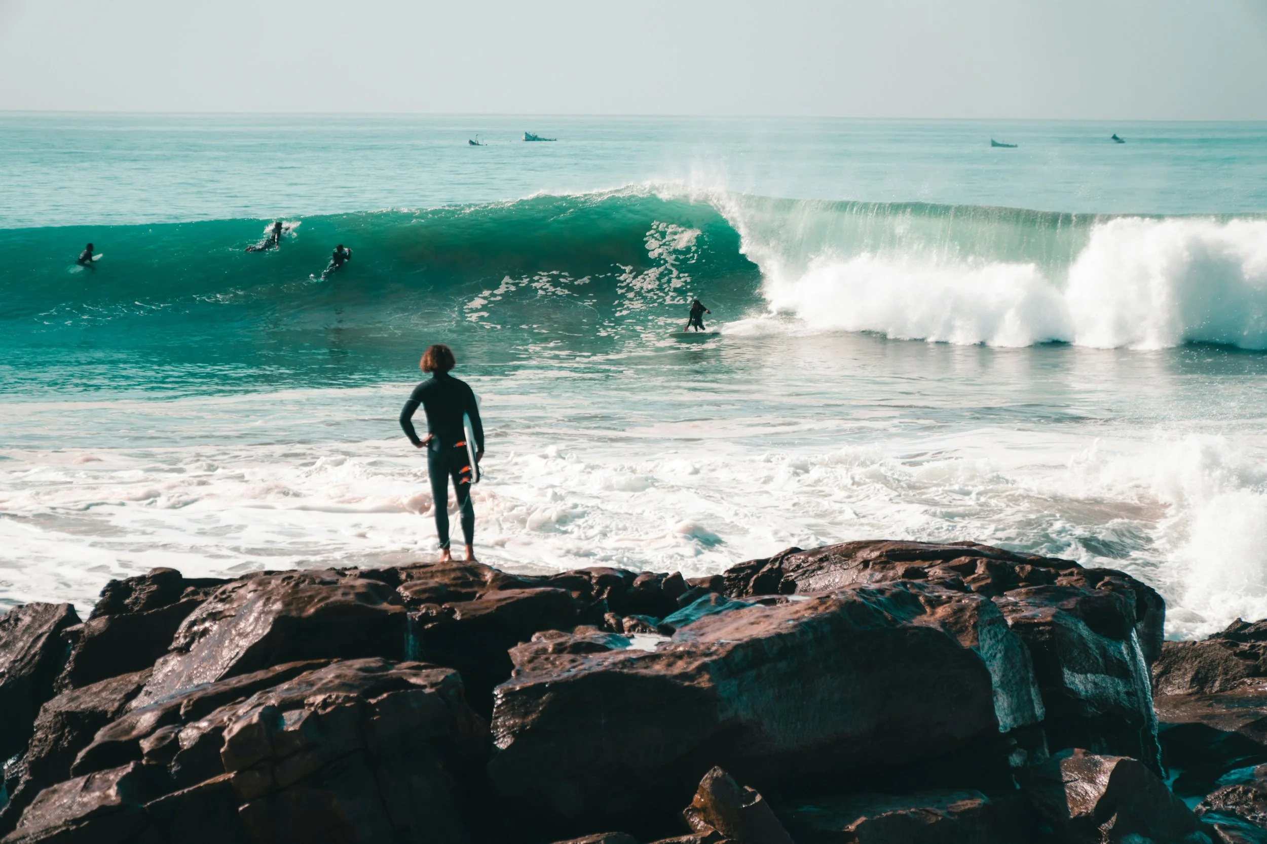 Surfer preparing to paddle out into powerful waves, highlighting the physical demands of surfing.